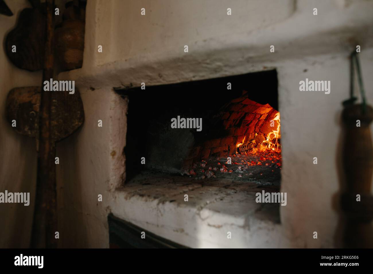 Ukrainischer traditioneller Ofen im Haus. Brennholz brennt im Ofen, Vorbereitung zum Brotbacken. Stockfoto