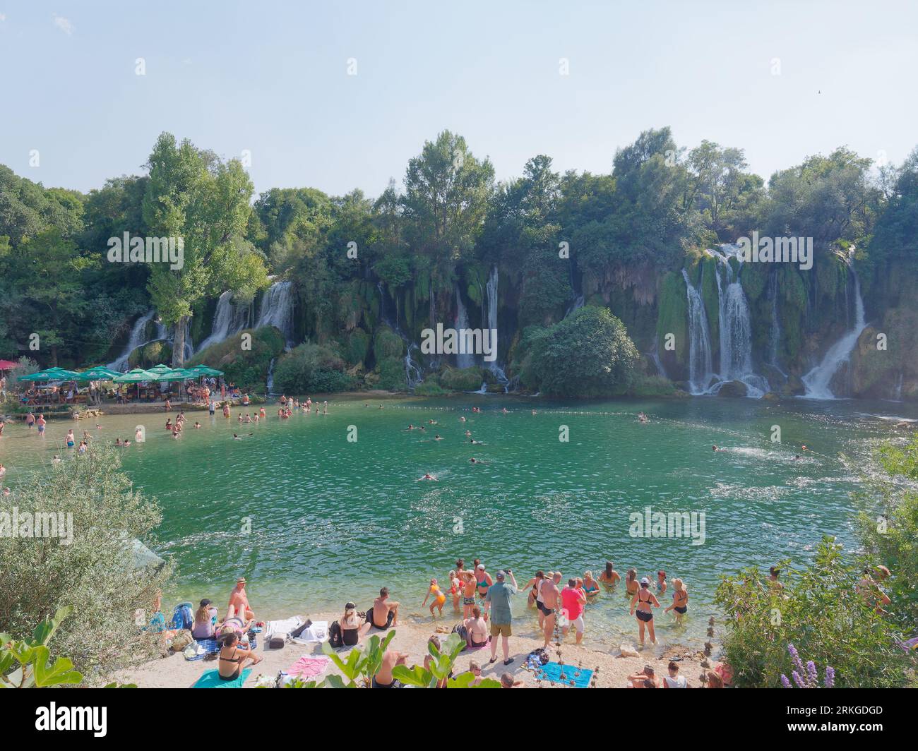 An einem Sommertag genießen die Menschen den Strandbereich am Kravica Wasserfall am Fluss Trebižat in einem Karstgebiet von Bosnien und Herzegowina. August 2023 Stockfoto