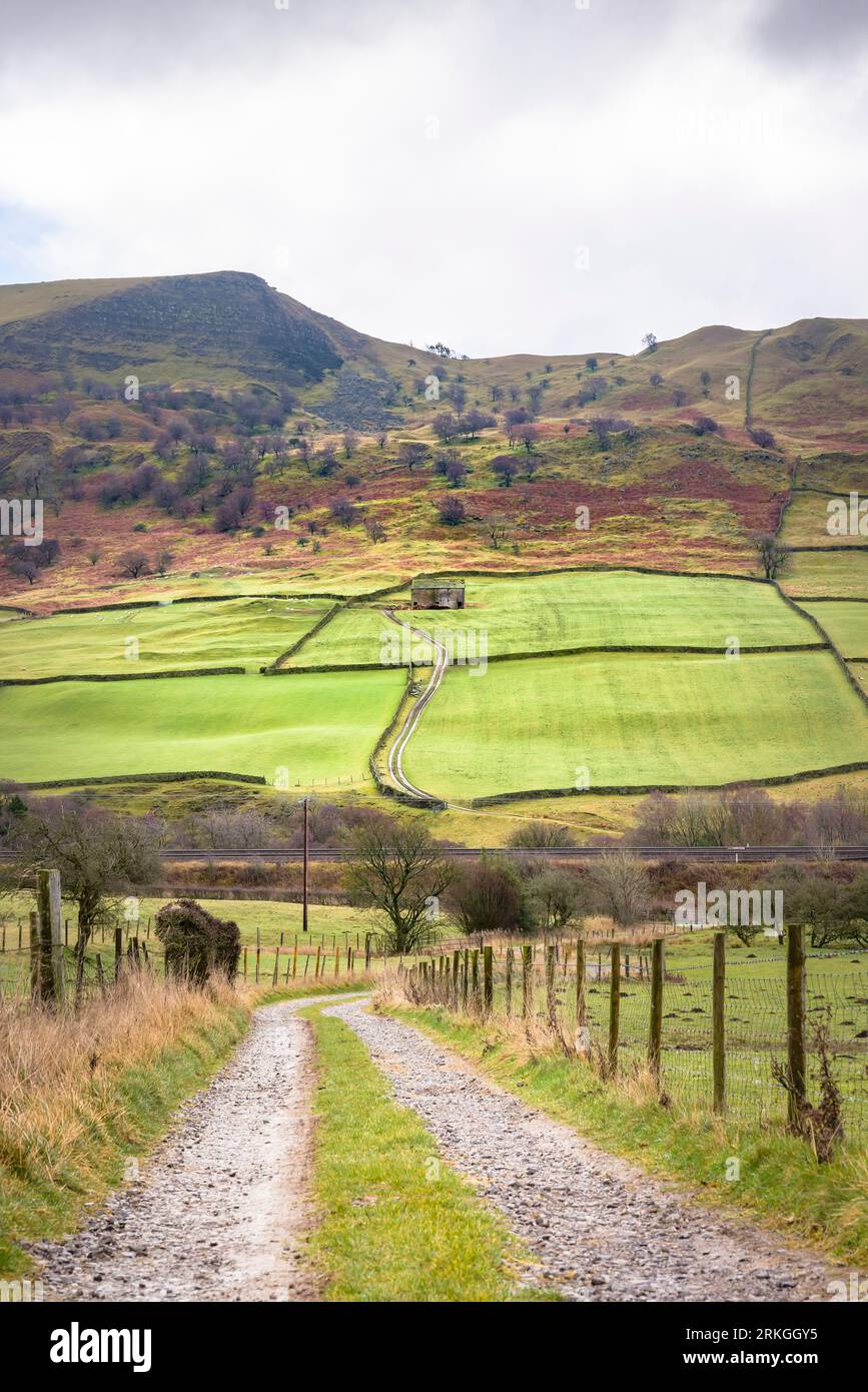 Derbyshire Landschaft im Winter mit Farm Track im Hope Valley, mit einer alten Steinscheune und Back Tor im Hintergrund. Peak District, Derbyshire, Großbritannien Stockfoto