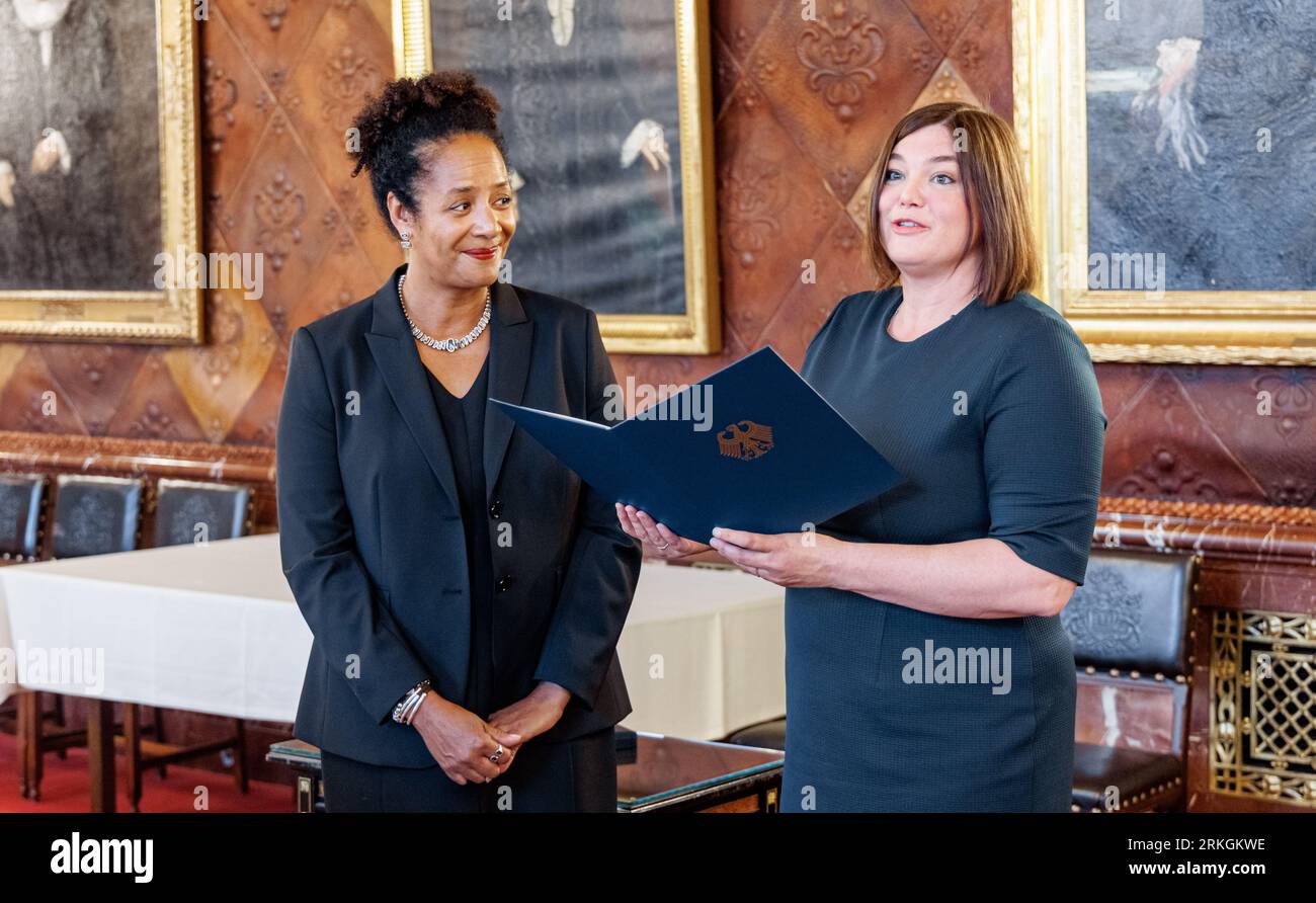 Hamburg, Deutschland. 25. August 2023. Katharina Fegebank (r, Bündnis90/Grüne), Hamburger Wissenschaftssenatorin, überreicht dem Hamburger Arzt Marylyn Addo das Bundesverdienstkreuz. Addo wird von der Bundespräsidentin für ihre Forschung zur Virologie und zu neu entstehenden Infektionskrankheiten geehrt. Quelle: Markus Scholz/dpa/Alamy Live News Stockfoto