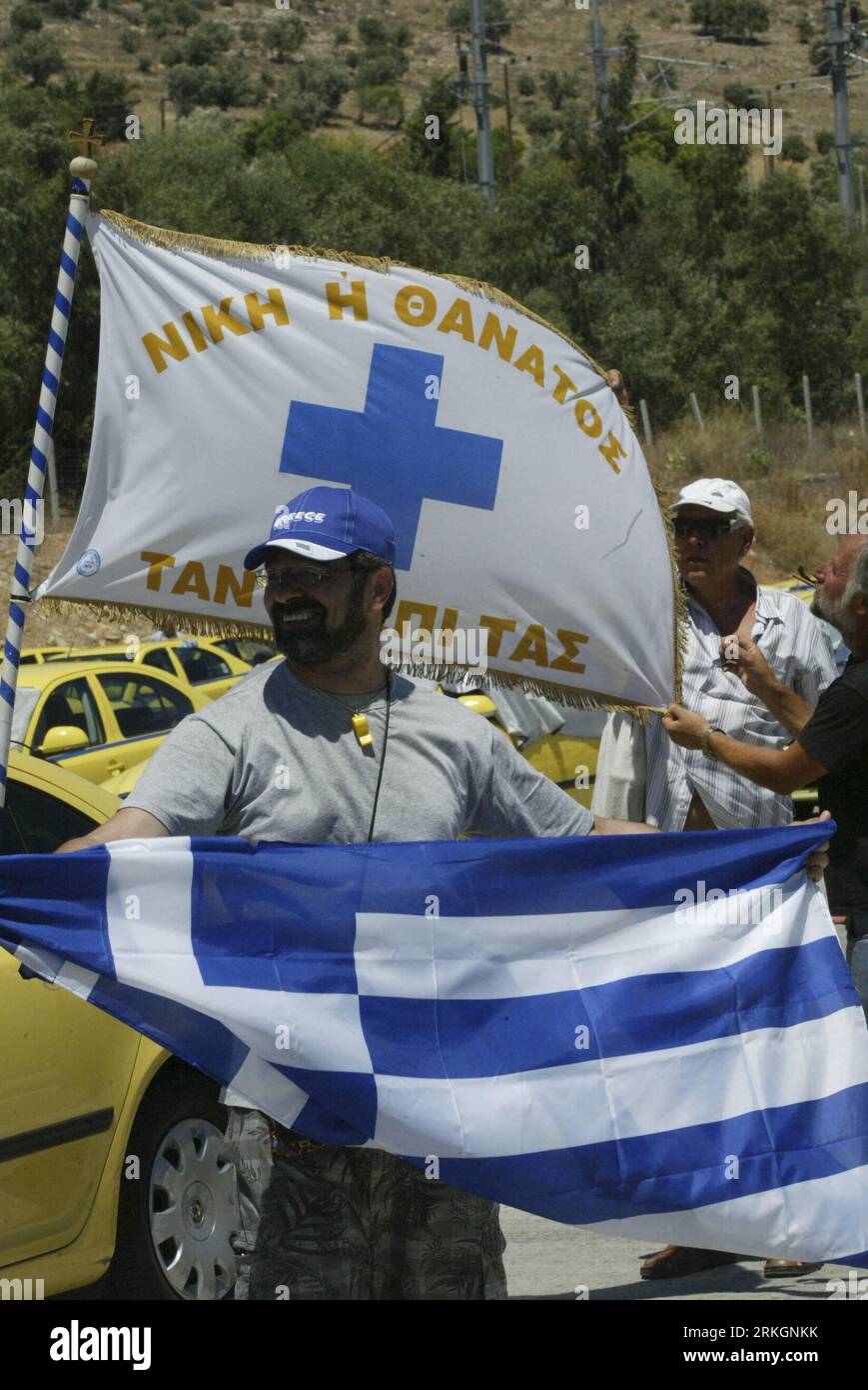 Bildnummer: 55610032 Datum: 22.07.2011 Copyright: imago/Xinhua (110722) -- AFIDNES (ATHEN), 22. Juli 2011 (Xinhua) -- Ein griechischer Taxifahrer hält eine Flagge während eines Streiks an der Mautstation Afidnes am Ethniki Odos Highway am 22. Juli 2011, in dem er die Regierung auffordert, ihre Reformpolitik in diesem Sektor zu ändern. Dies ist der fünfte Tag seit dem Beginn der letzten Streikrunde am 18. Juli. (Xinhua/Marios Lolos) GRIECHENLAND-TAXI-FAHRER-STREIK PUBLICATIONxNOTxINxCHN Gesellschaft Politik Schuldenkrise Streik Taxi Taxifahrer Autobahn Mautstelle x0x xst Premiumd 2011 hoch Bildnummer 55610032 Da Stockfoto