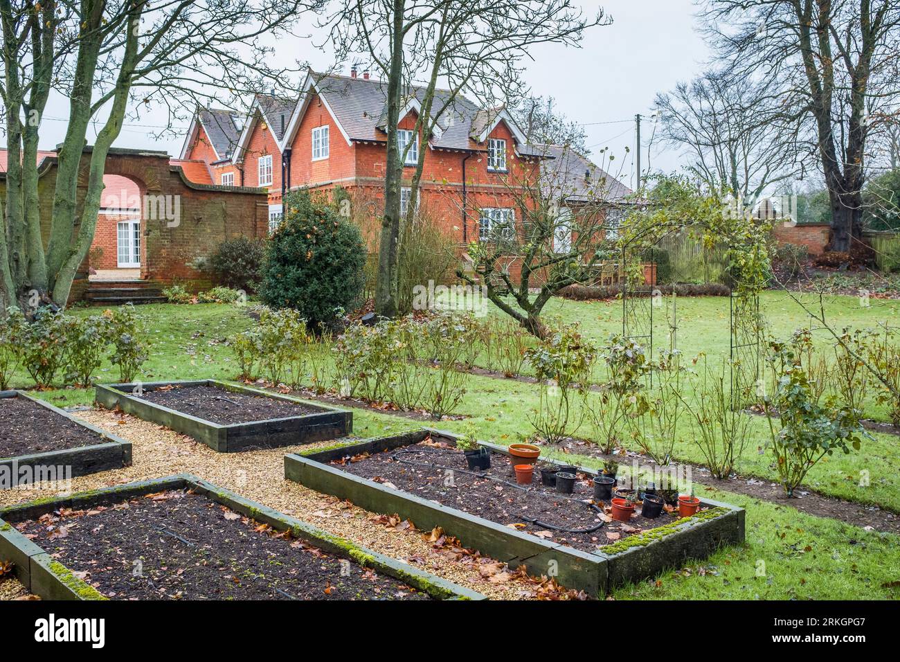 Viktorianisches Haus und Garten im Winter, Großbritannien, mit leeren Hochbeeten in einem Gemüsegarten Stockfoto
