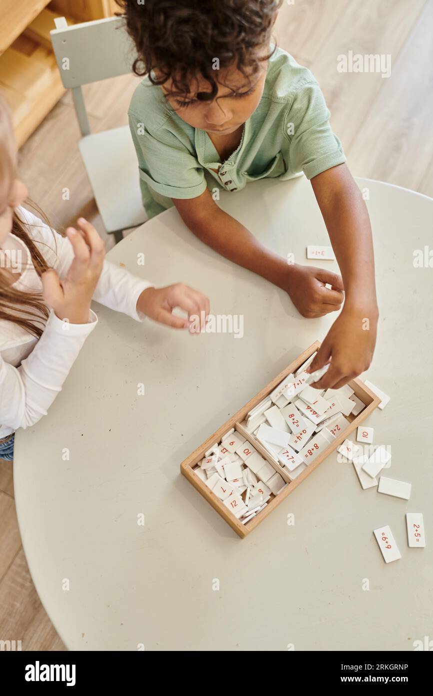 Mathematik lernen, afroamerikanischer Junge spielt mit Mädchen, montessori Schule, verschiedene Kinder, Blick von oben Stockfoto