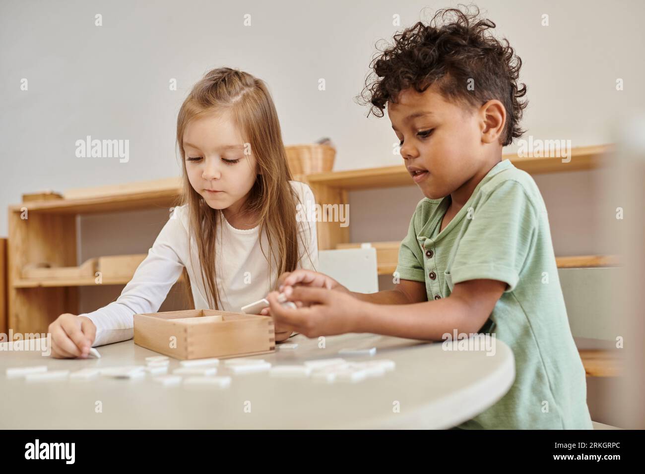 Mathematik lernen, verschiedene Kinder, afroamerikanischer Junge spielt mit Mädchen, montessori Schulkonzept Stockfoto