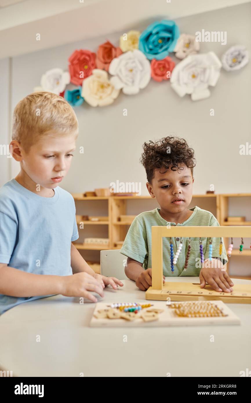 montessori Konzept, multikulturelle Jungen spielen mit farbigen Perlen Treppen, lernen durch Spiel, Kinder Stockfoto