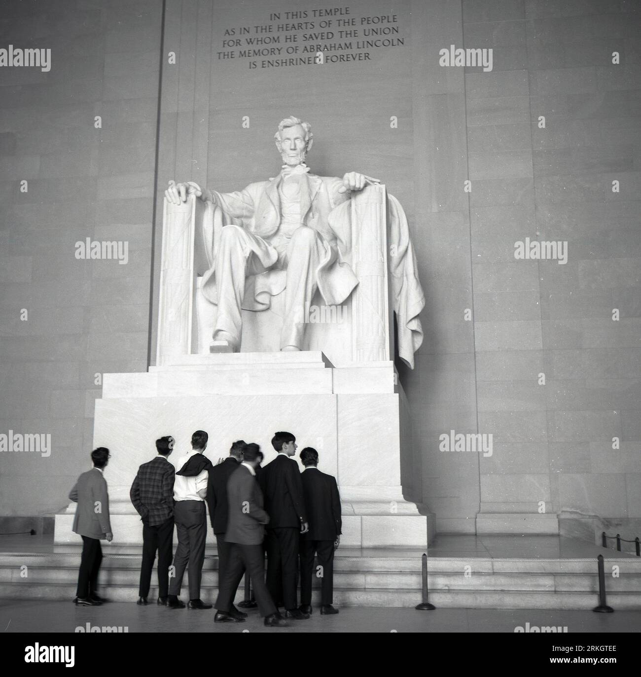 1960er Jahre, historisch, eine Gruppe junger Männer, die auf die große Marmorstatue von Abraham Lincoln, dem 16. US-Präsidenten, im Lincoln Memorial in Washington DC, USA blicken. Stockfoto