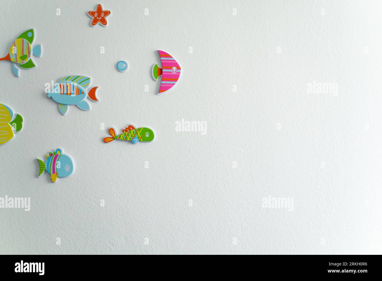 A close-up of a wall with colorful fish art Stockfoto
