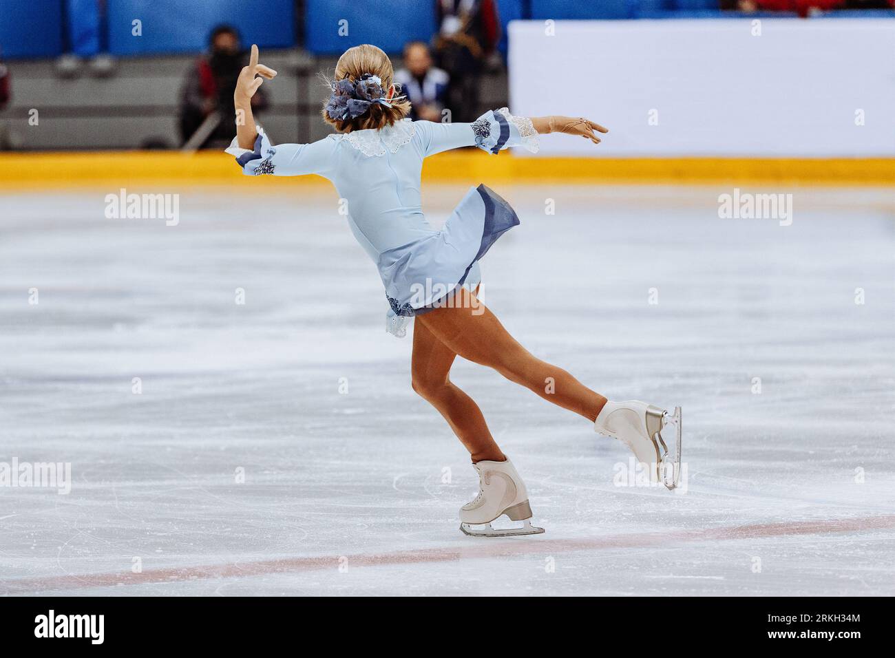 Eiskunstlauf Einzelfigur, Rückansicht Mädchen Eiskunstlauf in blauem Kleid Stockfoto