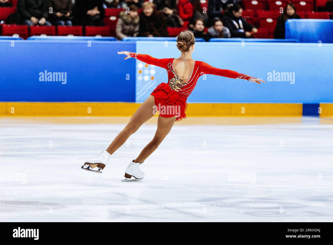 Eiskunstlauf Single, Rückenmädchen Figur Eiskunstlauf in rotem Kleid Stockfoto
