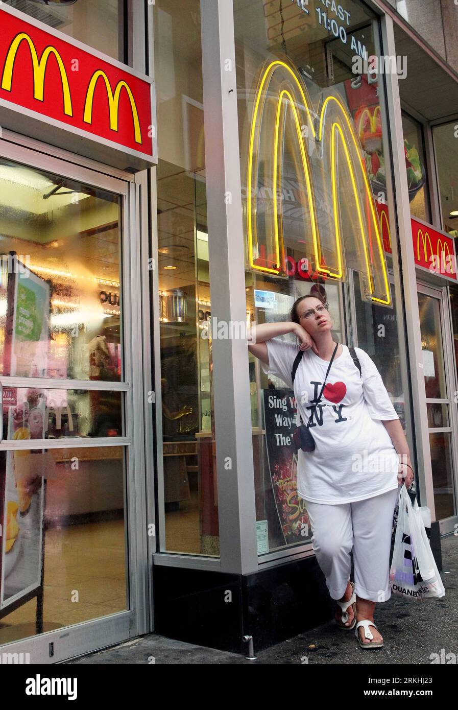 Bildnummer: 55834892 Datum: 27.08.2011 Copyright: imago/Xinhua (110828) -- NEW YORK, 28. August 2011 (Xinhua) -- Foto aufgenommen am 27. August 2011 zeigt, wie eine Frau vor einem geschlossenen McDonalds-Laden in Manhattan, New York, USA, Schutz vor dem Regen sucht. Der Bürgermeister von New York City erließ am Freitag erstmals einen Evakuierungsbefehl für mehr als 370.000 New Yorker, die in den tiefliegenden Gebieten leben, darunter South Beach auf Staten Island, Brighton Beach in Brooklyn und die Rockaways. Stadtbeamte sagten, dass 91 Unterkünfte auf höherem Boden eingerichtet wurden und damit begonnen haben, Bewohner aufzunehmen. Begi Stockfoto