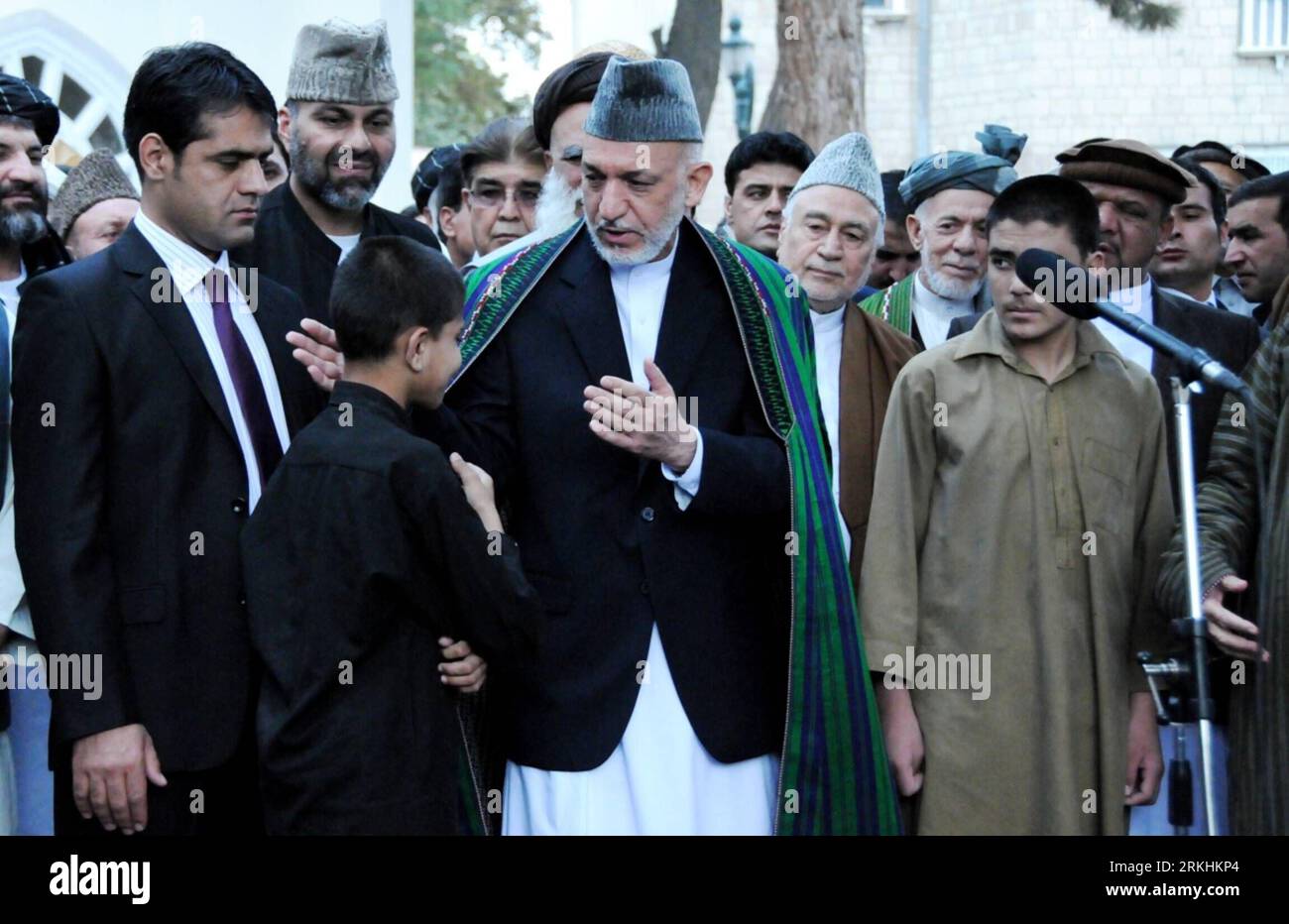 Bildnummer: 55853548  Datum: 30.08.2011  Copyright: imago/Xinhua (110830) -- KABUL, Aug. 30, 2011 (Xinhua) -- Afghan President Hamid Karzai embraces a would-be suicide bomber after Eid al-Fitr prayer during a ceremony to mark the release of eight suicide bombers who are under 18, at the presidential palace in Kabul on Aug. 30, 2011. Karzai on Tuesday called on Taliban to give up insurgency and join the peace and reintegration process, denouncing use of children as suicide bombers. (Xinhua/Omid) AFGHANISTAN-KABUL-KARZAI PUBLICATIONxNOTxINxCHN People Politik xtm 2011 quer premiumd     Bildnummer Stockfoto