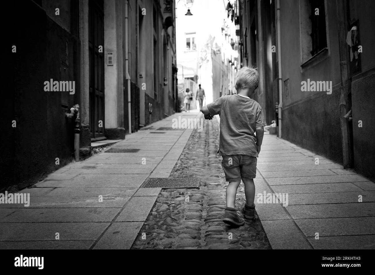 Kleiner Junge, der durch die Straßen von Cagliari auf Sardinien spaziert Stockfoto