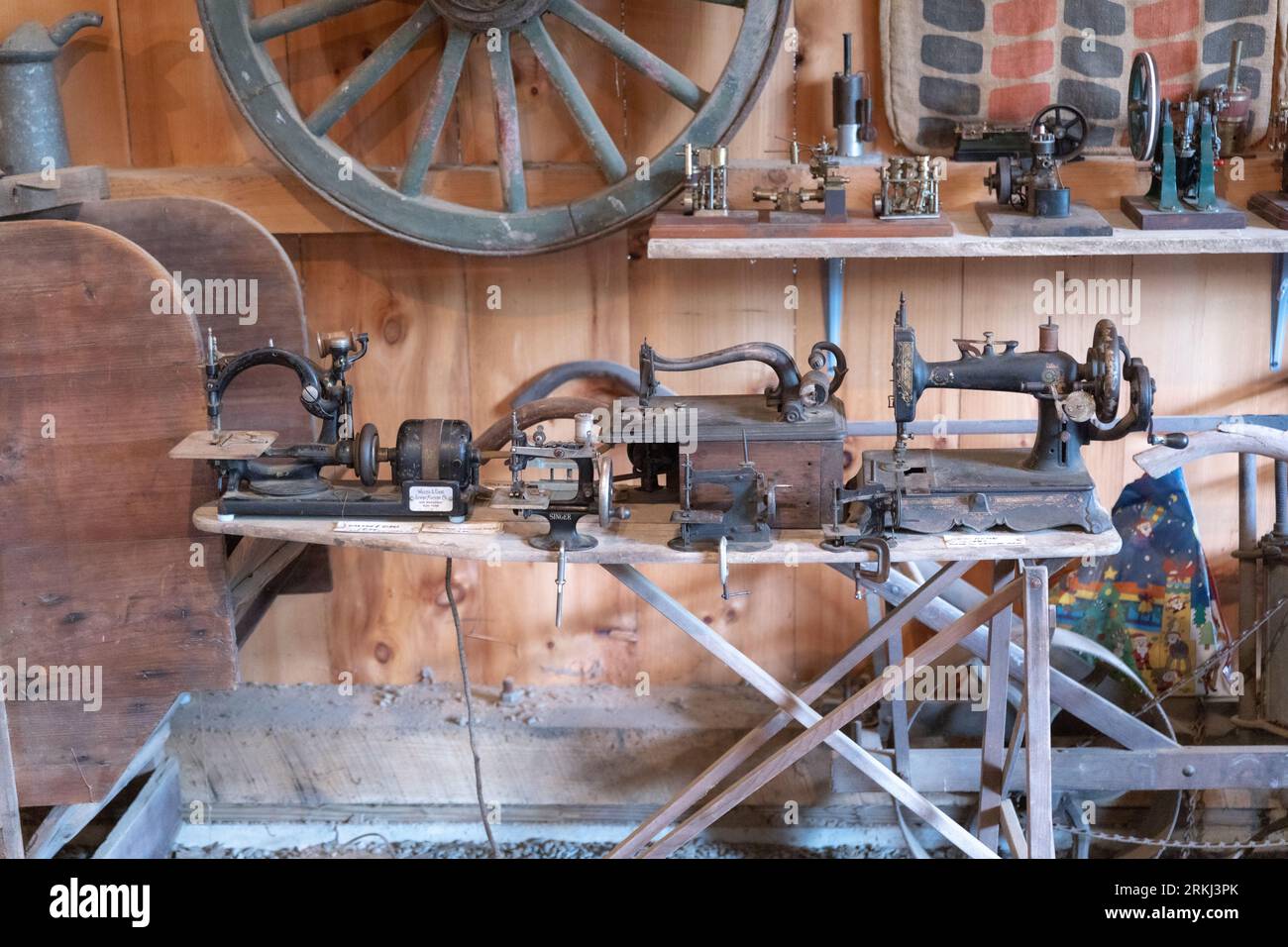 Verschiedene altmodische Nähmaschinen und Antiquitäten in einer rustikalen Holzscheune in Neuengland Stockfoto