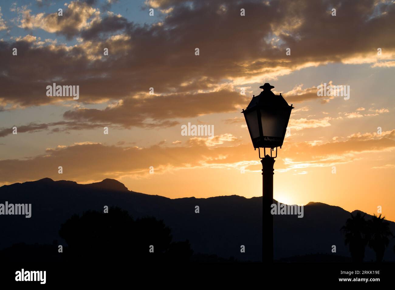 Sonnenuntergang auf dem Berg mit Silhouette der klassischen Laternenpfosten in Almudaina, Spanien Stockfoto
