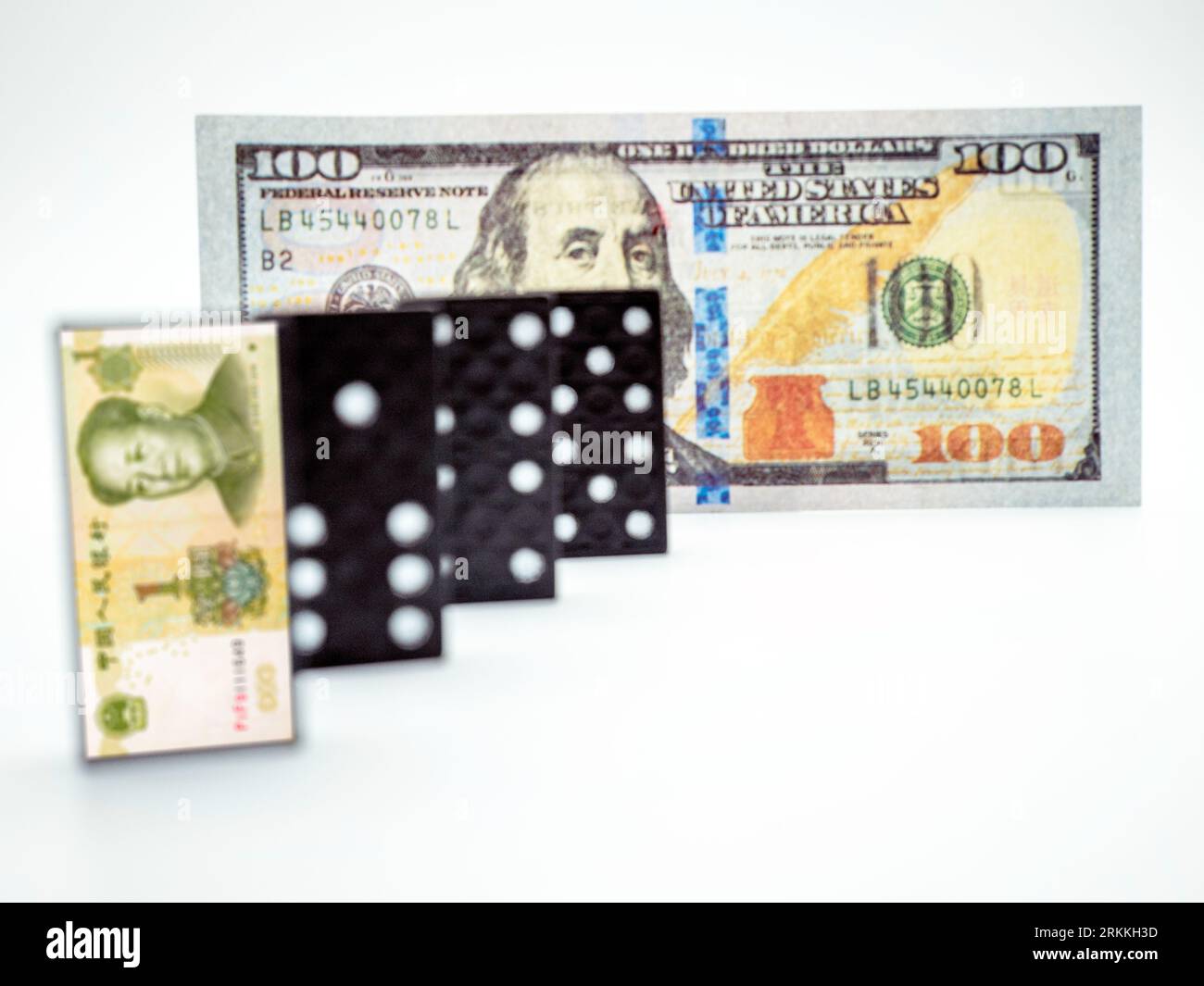 Yuan-Banknote auf Dominosteinen und Dollar auf weißem Hintergrund, Konzept der Finanzkrise Stockfoto