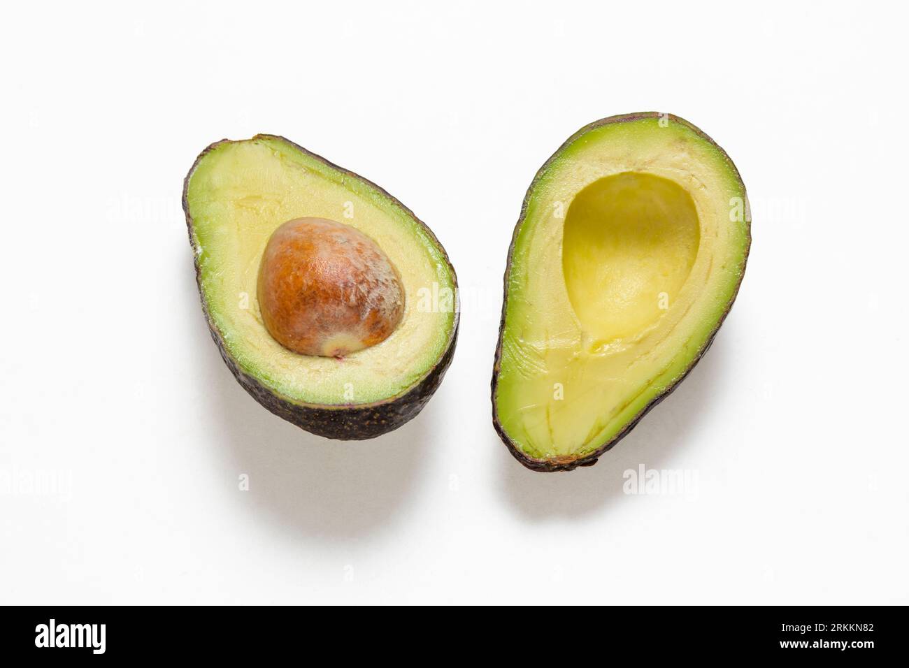 Zwei Scheiben Avocado isoliert auf einem weißen Hintergrund. Eine Scheibe mit Kern. Stockfoto