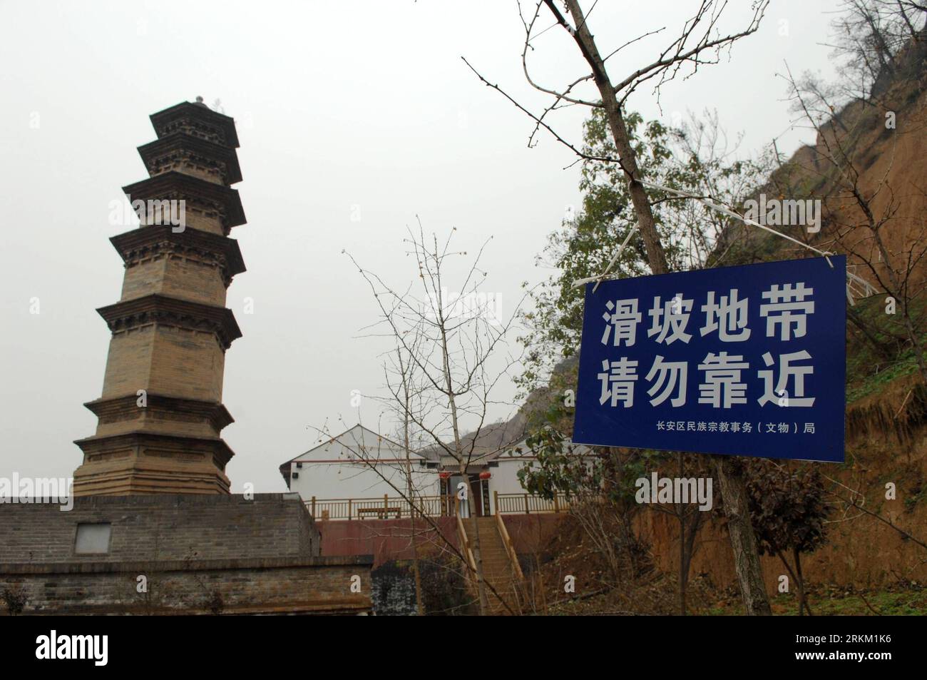 Bildnummer: 56365662 Datum: 21.11.2011 Copyright: imago/Xinhua (111121) -- XI AN, 21. November 2011 (Xinhua) -- Ein Schild mit der Aufschrift Erdrutschzone, Keep Away ist neben dem Miaojue Tower des Huayan Tempels in Xi an, der Hauptstadt der nordwestlichen chinesischen Provinz Shaanxi, 21. November 2011 zu sehen. Die zwei Jahrtausende alten Türme im Huayan-Tempel sind bedroht, da in den letzten Monaten aufgrund von starken Regenfällen mehrere Erdrutsche auf die Hügel um den Tempel herum stattfanden. Der Fuß eines der Türme ist teilweise freigelegt und der Boden in der Nähe des Turms ist mit einer meterlangen Spalte gebrochen. Als Xi an fahren Sie fort Stockfoto