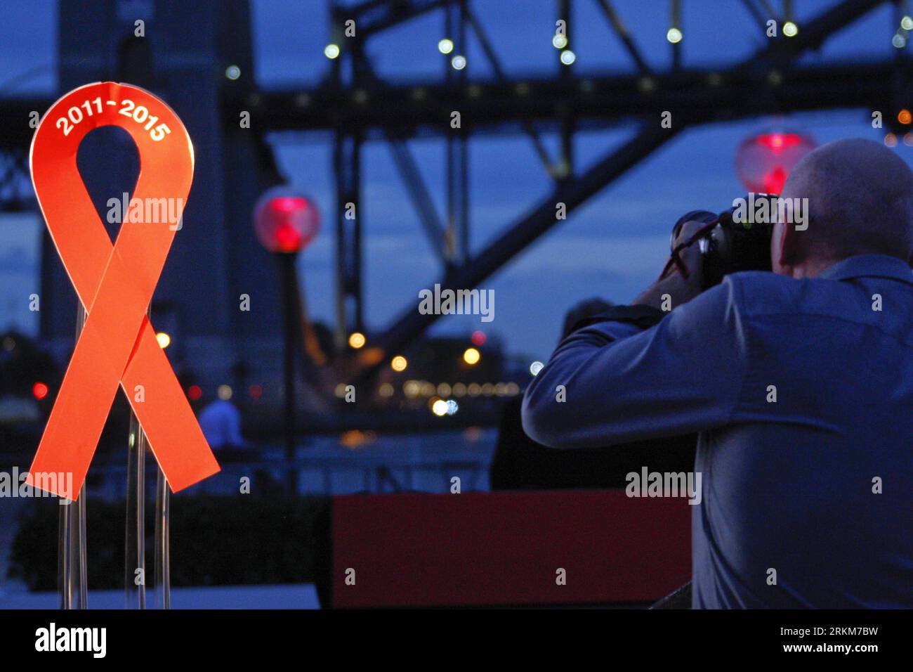 Bildnummer: 56536970 Datum: 30.11.2011 Copyright: imago/Xinhua (111130) -- SYDNEY, 30. November 2011 (Xinhua) -- Ein Journalist macht ein Foto des Logos des Welt-Aids-Tages während einer Aktivität anlässlich des bevorstehenden jährlichen Welt-Aids-Tages, der am 1. Dezember 2011 im Sydney Opera House, Australien, 30. November, stattfindet. (Xinhua/Jin Linpeng) (jl) AUSTRALIA-SYDNEY-WORLD AIDS DAY PUBLICATIONxNOTxINxCHN Gesellschaft Gedenken Weltaidstag AIDS HIV xbs x0x 2011 quer 56536970 Datum 30 11 2011 Copyright Imago XINHUA Sydney Nov 30 2011 XINHUA ein Journalist nimmt ein Foto des Wappens des Welt-AIDS-Tages während der Aktivität auf Stockfoto