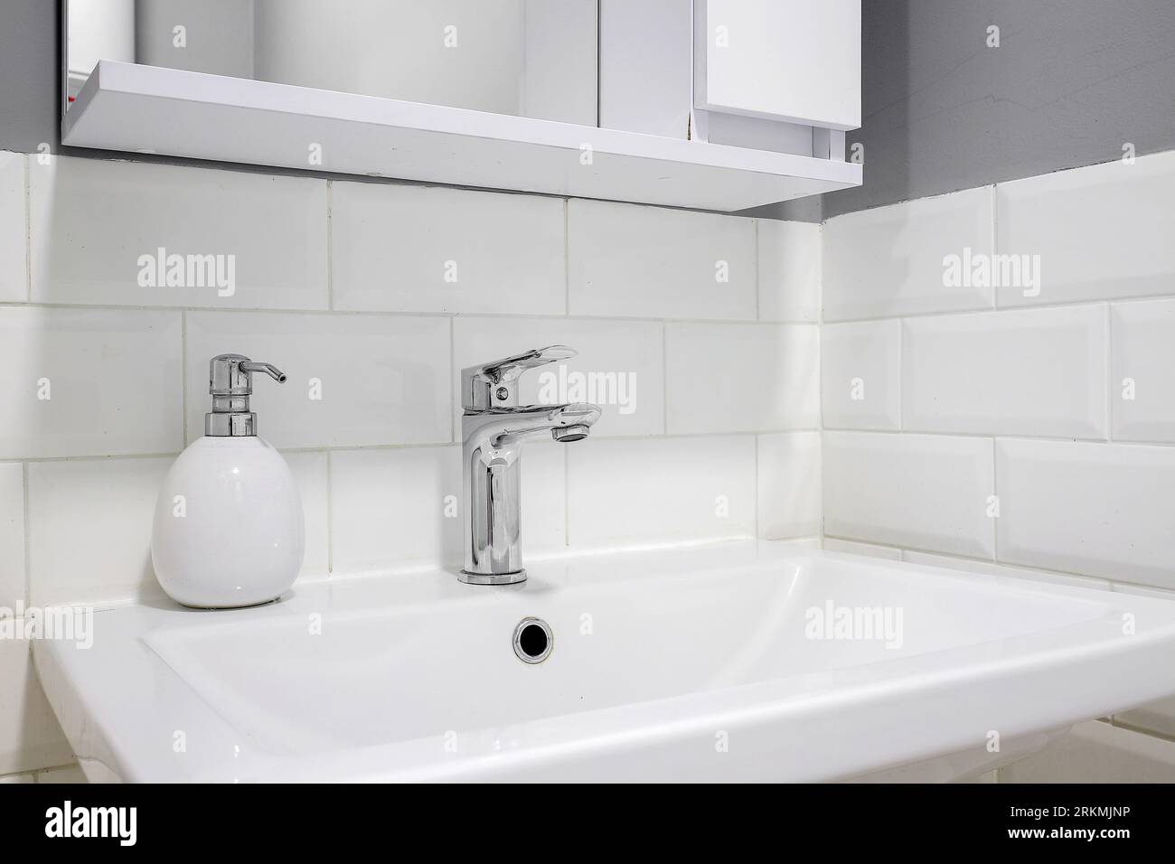 Chrom-Wasserhahn mit weißem Keramikwaschbecken im Badezimmer Stockfoto