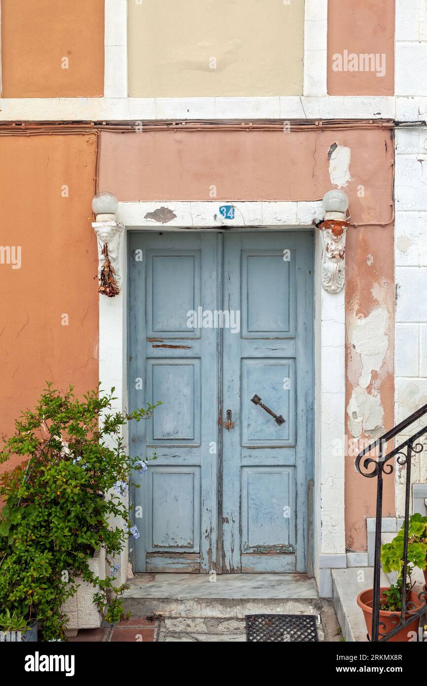 Traditioneller Eingang aus Holz mit Doppeltüren, einem Steinsturz und einer Türschwelle und einer ockerfarbenen Mauer in Parga, Preveza, Griechenland Stockfoto