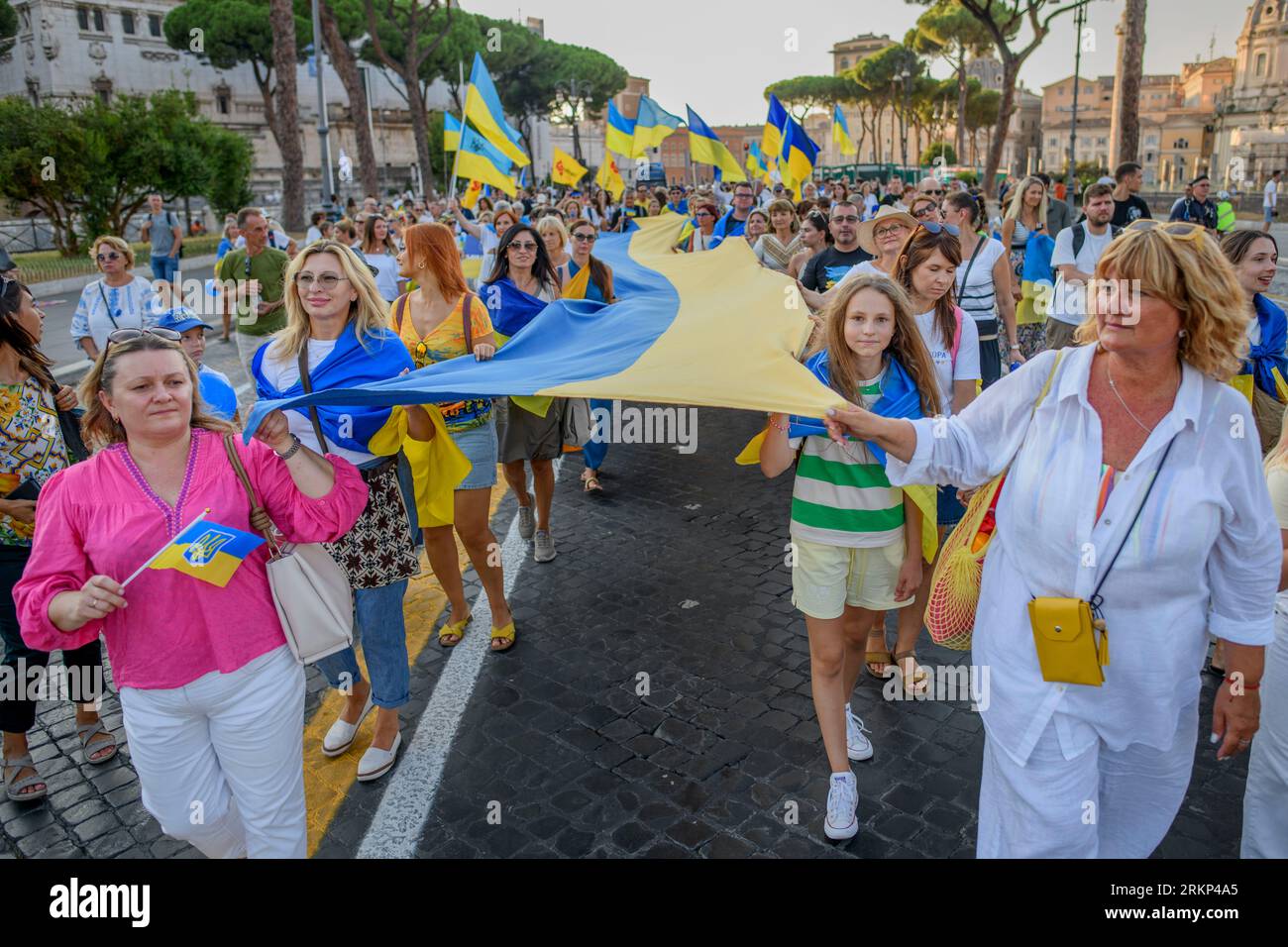 Rom, Italien. August 2023. Ukrainische Frauen tragen eine lange Flagge der Ukraine während des ukrainischen Unabhängigkeitstages in Rom. Am 24. August feiern die Ukrainer den Unabhängigkeitstag der Ukraine, um der Unabhängigkeitserklärung von 1991 von der UdSSR zu gedenken. Nach Schätzungen des UNHCR haben seit der russischen Invasion rund 6 Millionen Flüchtlinge die Ukraine verlassen, etwa 170.000 würden in Italien leben. (Bild: © Marcello Valeri/ZUMA Press Wire) NUR REDAKTIONELLE VERWENDUNG! Nicht für kommerzielle ZWECKE! Stockfoto