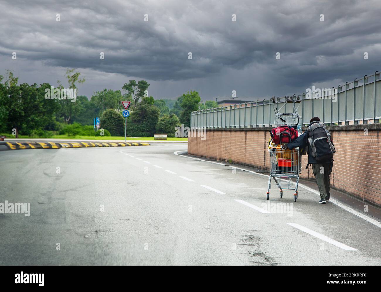 Obdachlose schiebt den Einkaufswagen auf die Straße Stockfoto
