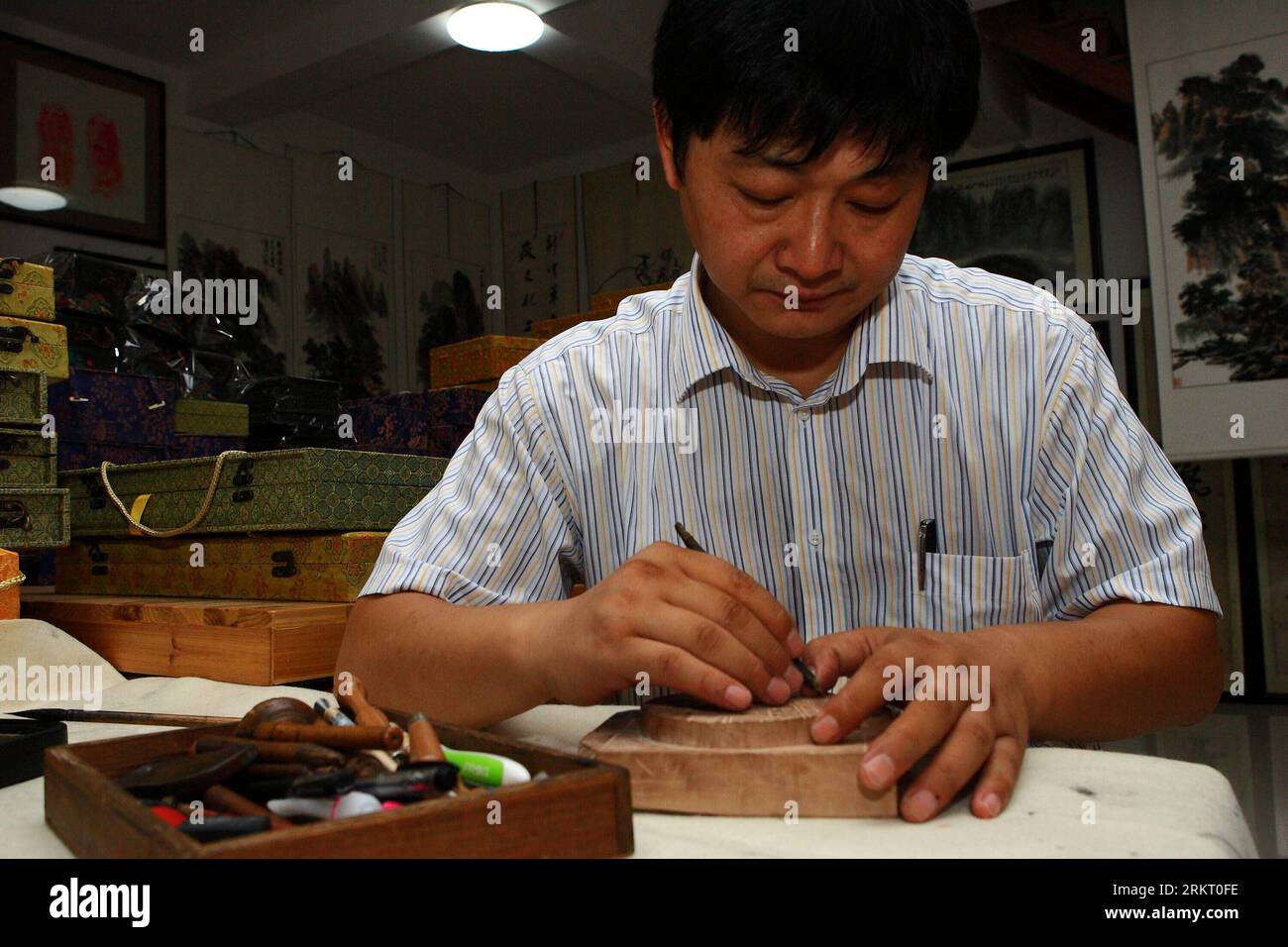 Bildnummer: 58338522 Datum: 12.08.2012 Copyright: imago/Xinhua (120812) -- HEFEI, 12. August 2012 (Xinhua) -- Xiang Shigan schnitzt auf einem Stück Musterform für die Herstellung von Tintenstöcken im Bezirk Shexian der ostchinesischen Provinz Anhui, 8. August 2012. Der 43-Jährige Xiang Shdak führte die Handwerkskunst des Entwerfens und der Herstellung von Tintenstiften von seinem Vater fort, einem leitenden Handwerker in diesem Geschäft. Xiang begann 1987 sein eigenes Tintenstifthandel. Nach 20 Jahren Forschung und Entwicklung förderte Xiang die traditionelle Technologie und entwickelte eine Reihe neuer Musterdesigns. Derzeit ist Xiang der preisgekrönte Stockfoto