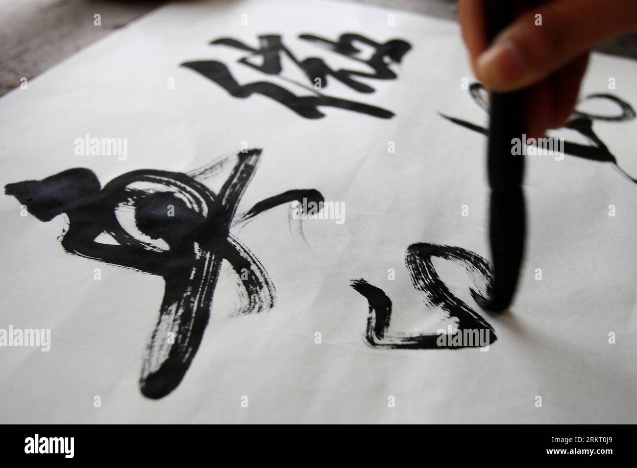 Bildnummer: 58338533 Datum: 12.08.2012 Copyright: imago/Xinhua (120812) -- HEFEI, 12. August 2012 (Xinhua) -- Ein Kunde schreibt mit der Tinte, die aus den Tintenstiften gemahlen wurde, die Xiang Shigan im Bezirk Shexian der ostchinesischen Provinz Anhui, 8. August 2012, hergestellt hat. Der 43-Jährige Xiang Shdak führte die Handwerkskunst des Entwerfens und der Herstellung von Tintenstiften von seinem Vater fort, einem leitenden Handwerker in diesem Geschäft. Xiang begann 1987 sein eigenes Tintenstifthandel. Nach 20 Jahren Forschung und Entwicklung förderte Xiang die traditionelle Technologie und entwickelte eine Reihe neuer Musterdesigns. Derzeit ist Xiang der Awar Stockfoto