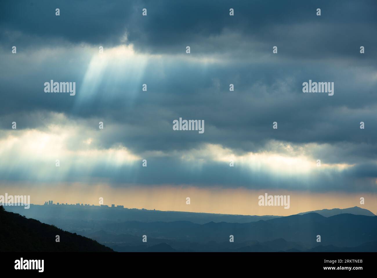 Himmlische Strahlkraft: Krepuskuläre Strahlen, die die dynamische Wolkenlandschaft erleuchten. Die Wufenshan Weather Radar Station steht auf dem Gipfel des Berges. Taiwa Stockfoto