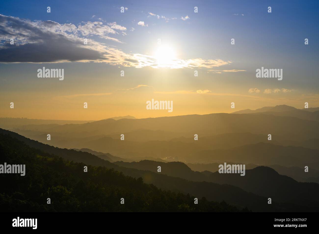 Die Sonne bewegt sich in Richtung der Berge am Horizont. Die Wufenshan Weather Radar Station steht auf dem Gipfel des Berges. Taiwan Stockfoto