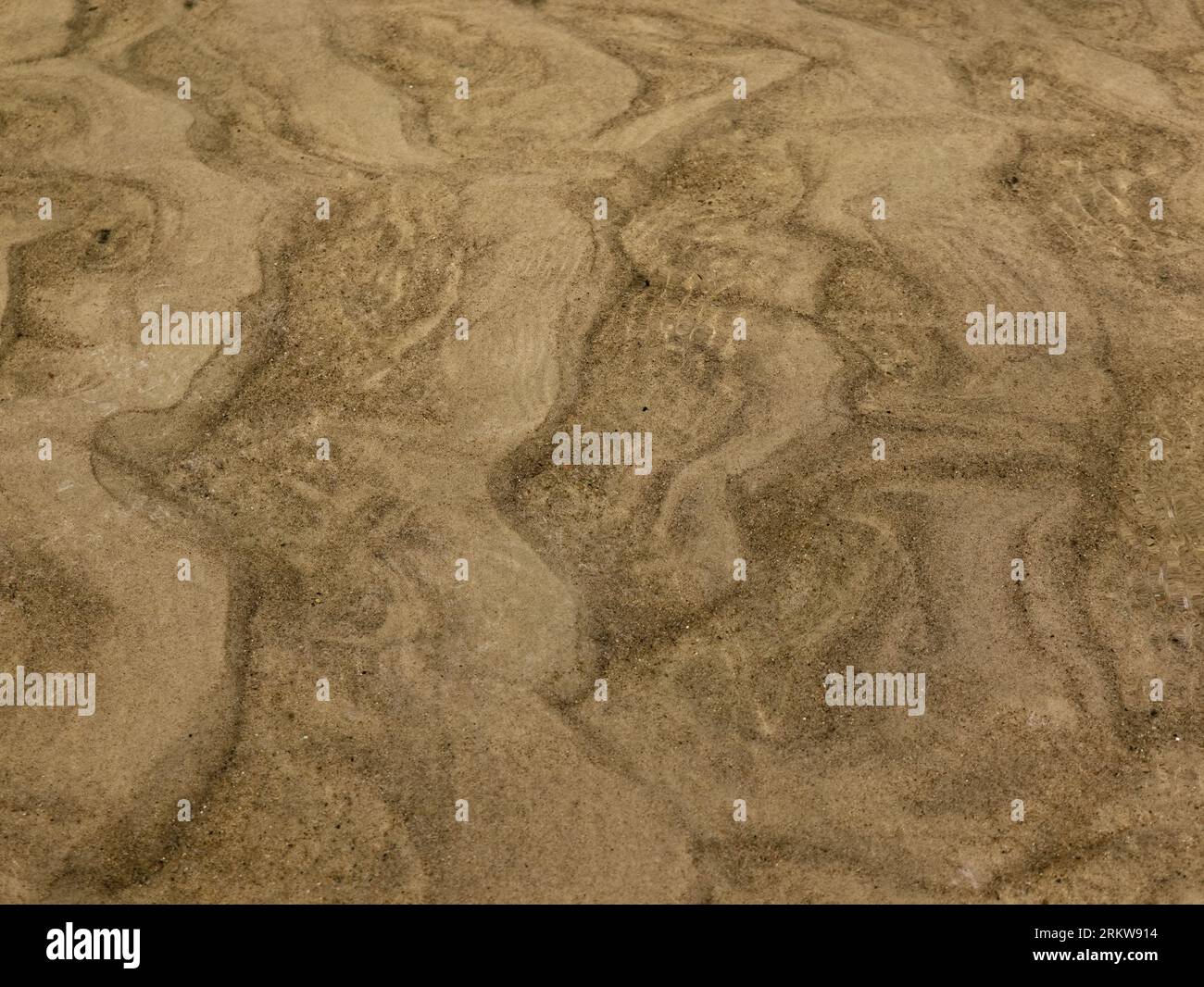 Ein seichter Fluss mit sandigem Boden, mit malerischen Sandwellen, die vom Wasser erzeugt werden Stockfoto