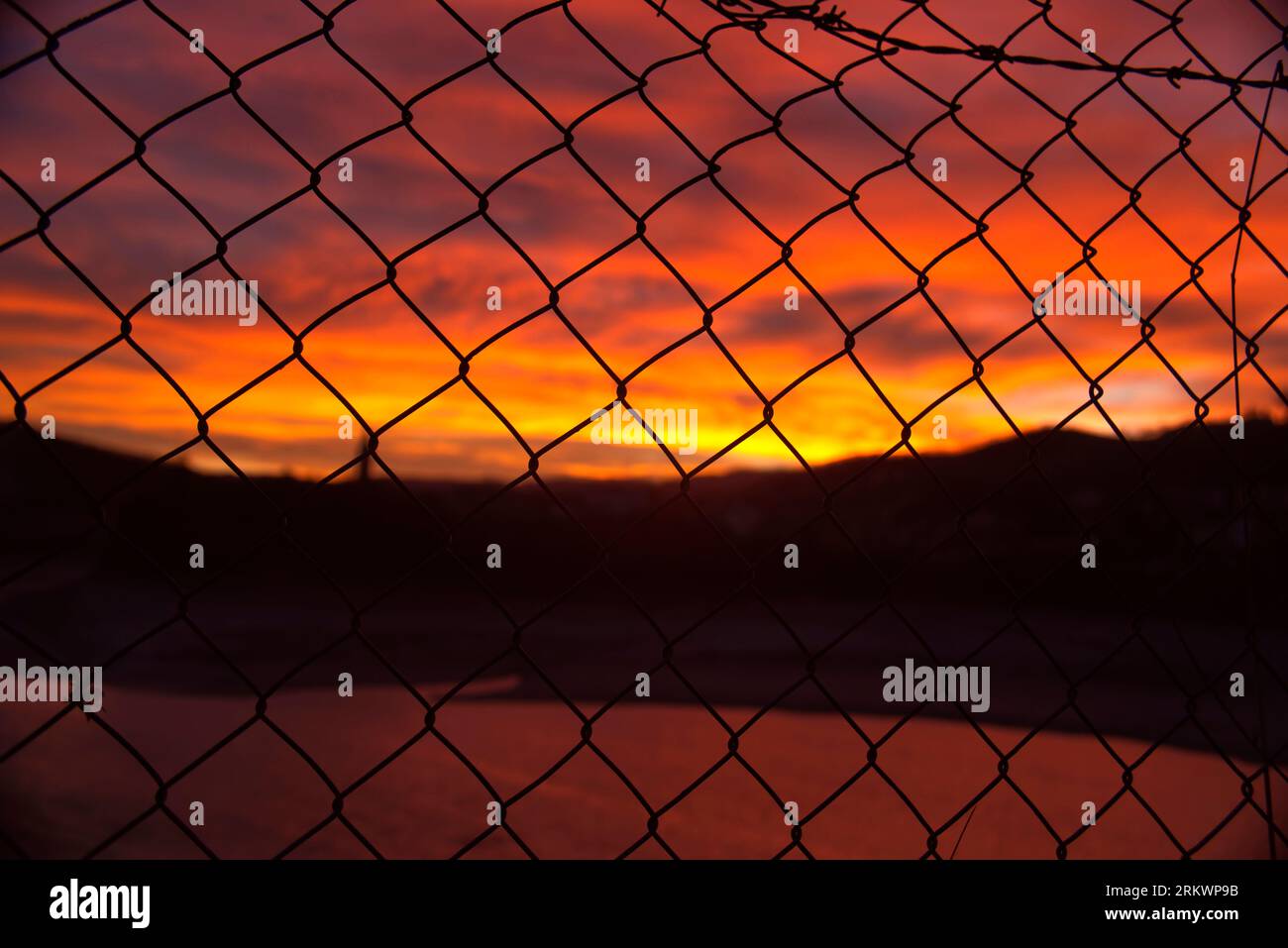 tramonto sul lago attraverso la recinzione Stockfoto