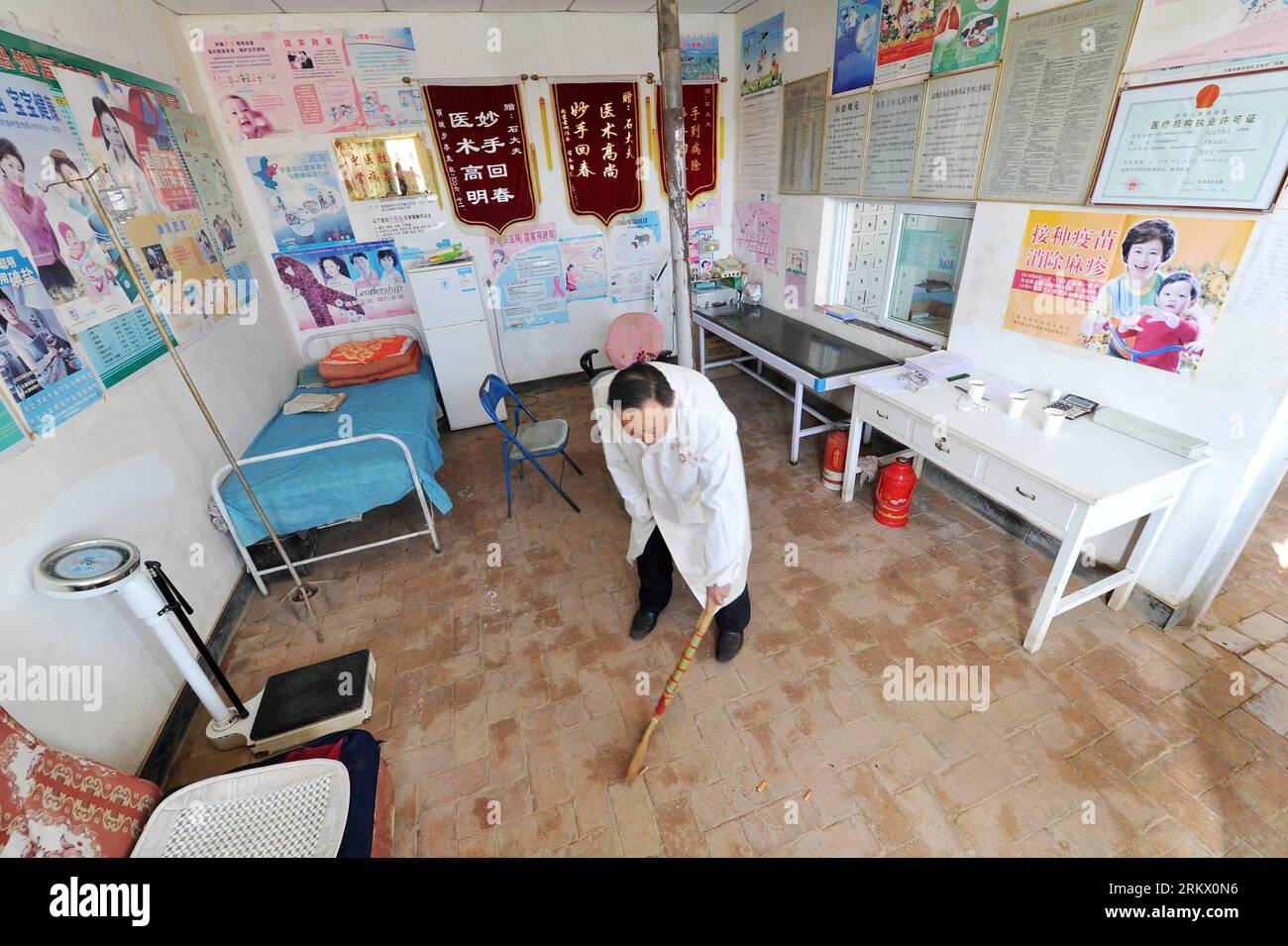 Bildnummer: 58850757 Datum: 28.11.2012 Copyright: imago/Xinhua (121129) -- YANCHI, November 28, 2012 (Xinhua) -- Dorfarzt Shi Weilin fegt die Dorfklinik in der Stadt Dashuikeng im Yanchi County, nordwestchinesische Autonome Region Ningxia Hui, November 28, 2012. Der 64-jährige Dorfarzt Shi Weilin ist bekannt für seine Geldlosigkeit und die Schwere der Krankheit. In den letzten 40 Jahren hat er zahllose Einsparungen erzielt, unabhängig von den Erschwinglichkeiten der Behandlung, mit fast 100 IOUs in Höhe von insgesamt über 20.000 Yuan (3.200 US-Dollar). Er baute sogar seine eigene Ho um Stockfoto