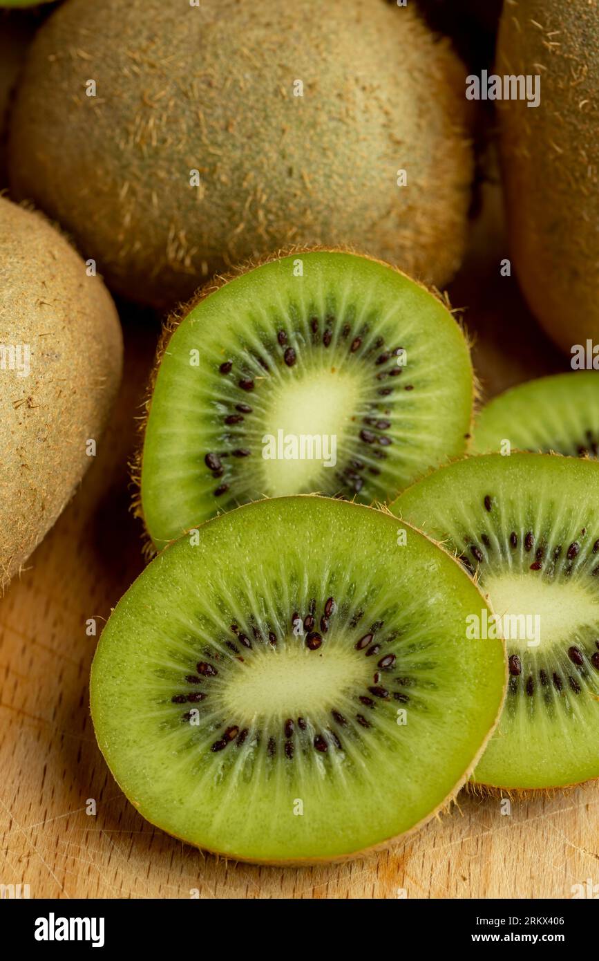 Eine Gruppe geschnittener grüner Kiwifrüchte mit schwarzen Samen, Details von in Stücke geschnittenem grünem Kiwipulp Stockfoto