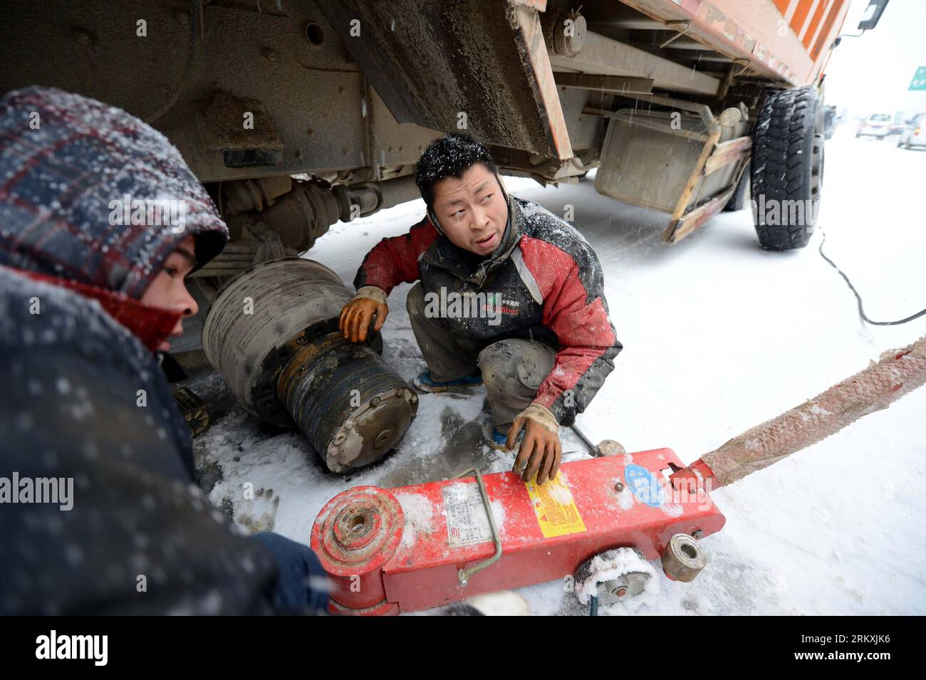Bildnummer: 58963599 Datum: 04.01.2013 Copyright: imago/Xinhua (130104) -- NANCHANG, 4. Januar 2013 (Xinhua) -- Ein Fahrer repariert seinen Lkw auf einer vereisten Straße in Nanchang, der Hauptstadt der ostchinesischen Provinz Jiangxi, am 4. Januar 2013. Die meisten Autobahnen in Jiangxi waren gefroren und einige waren aufgrund des starken Schnees seit Donnerstagabend blockiert. Die Wetterbeobachtungsstelle der Provinz gab am Freitag einen orangen Alarm auf der eisigen Straße aus. (Xinhua/Zhou Ke) (zz) CHINA-JIANGXI-NANCHANG-ICE ROAD (CN) PUBLICATIONXNOTXINXCHN Gesellschaft Wetter Jahreszeit Winter Schnee Eis kalt Kälte Verkehr Strassenverkehr x0x xmb 2013 qu Stockfoto