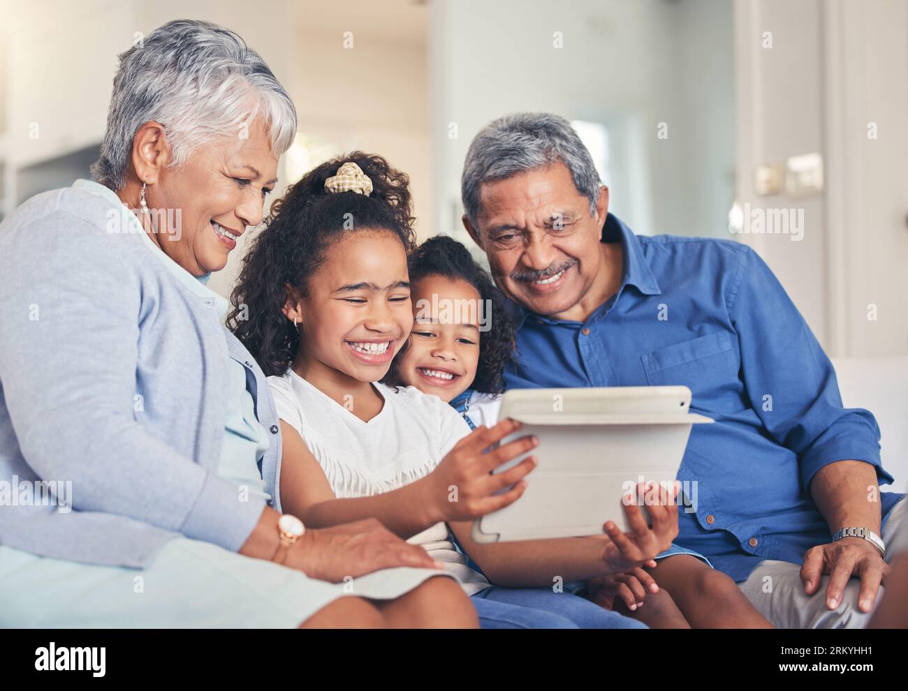 Familie. Großeltern und Kinder auf dem Tablet für Selfie, Video-Streaming und E-Learning, Online-Bildung oder Spiele auf dem Sofa. Senioren und Kinder weiter Stockfoto