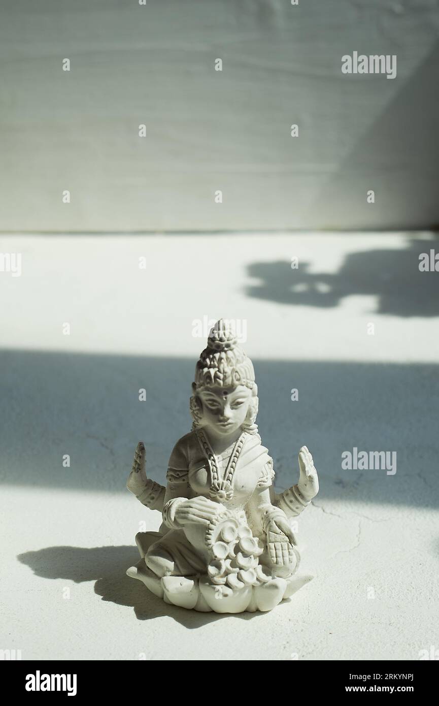 Göttin Lakshmi und eine Kerze mit drei Holzfässern. Esoterik, Religion. Überfluss Stockfoto
