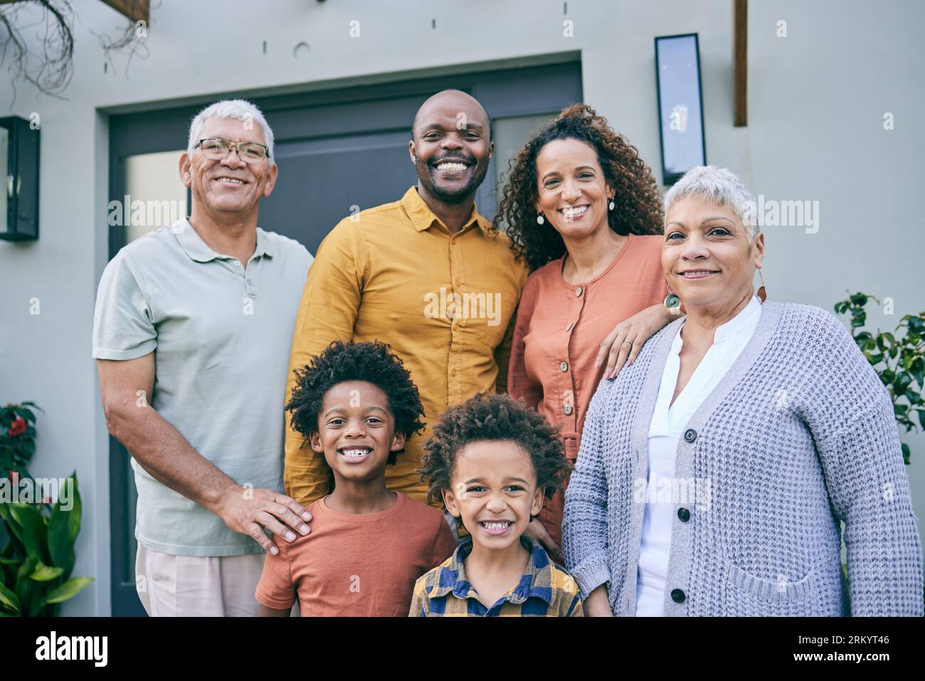 Porträt, Lächeln und große Familie zu Hause, interrassisch und Spaß zusammen im Hinterhof. Gesicht, Großeltern und Kinder, Mutter und Vater glücklich Stockfoto