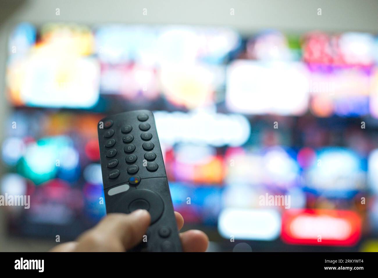 Hand mit TV-Fernbedienung, um TV-Serien von der Streaming-Service-Plattform zu wechseln. Die neue Art, Unterhaltung zu Hause zu genießen. Stockfoto