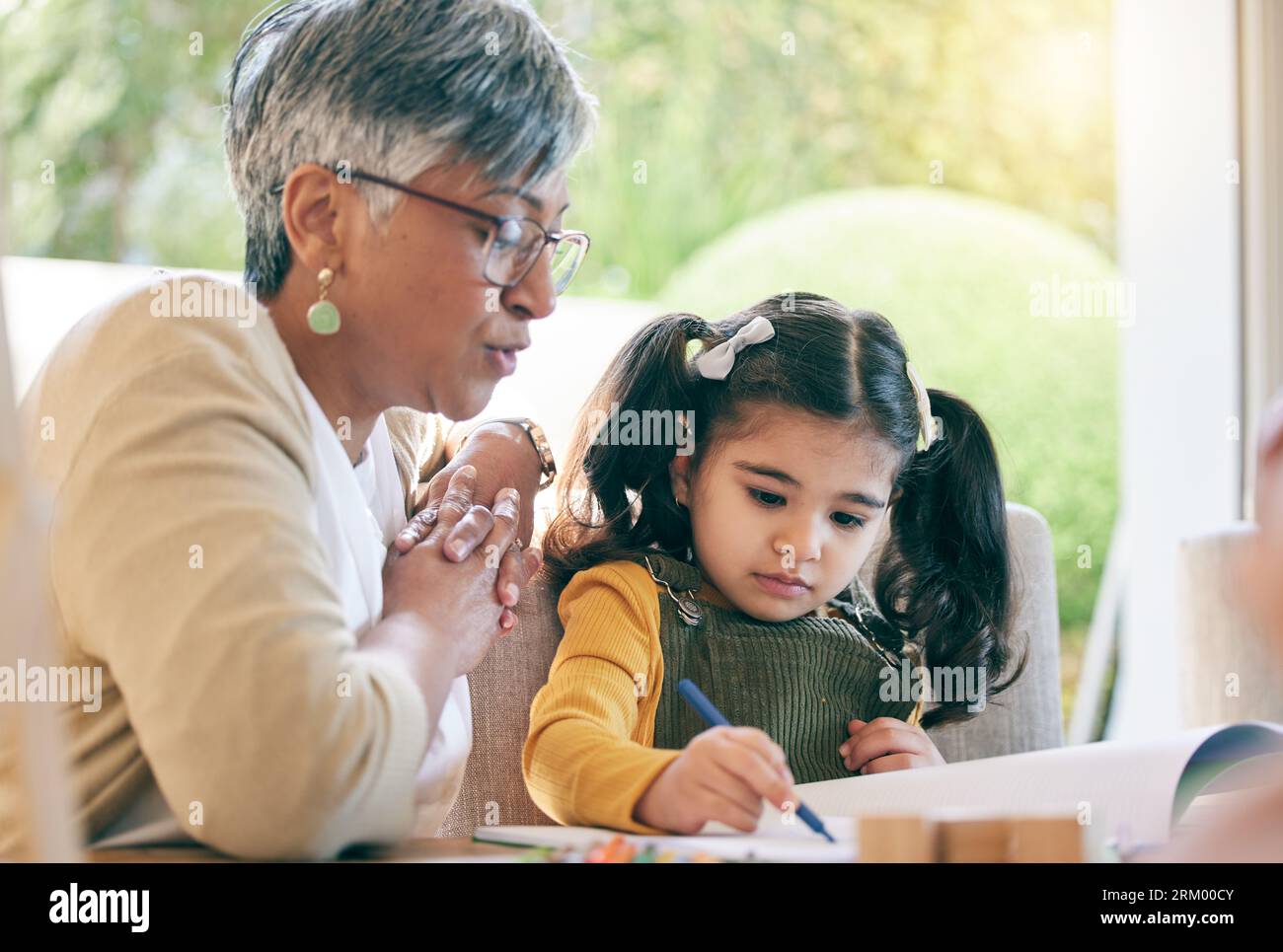 Unterrichten, Großmutter oder Mädchen lernen Zeichnen im Buch für kreative Fähigkeiten oder Entwicklungsmöglichkeiten. Senior, Support oder reife Großmutter, die einem hilft Stockfoto