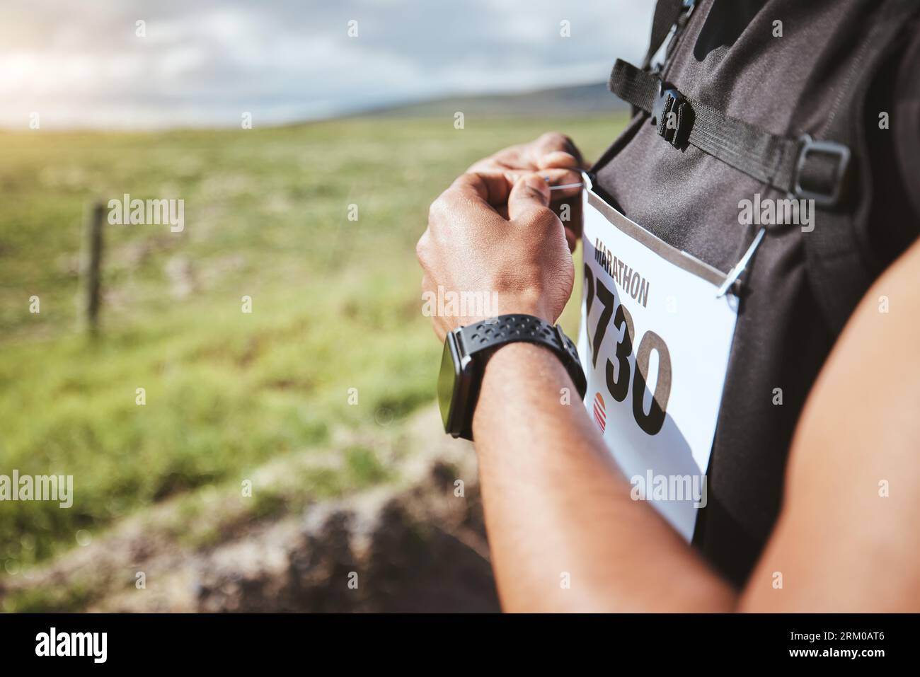 Hände, Marathon und Lätzchen von Mann im Freien für Lauftraining, Training und gesunden Körper. Sport-, Wettkampf- und Wettkampfnummer des Athleten im Kardio Stockfoto