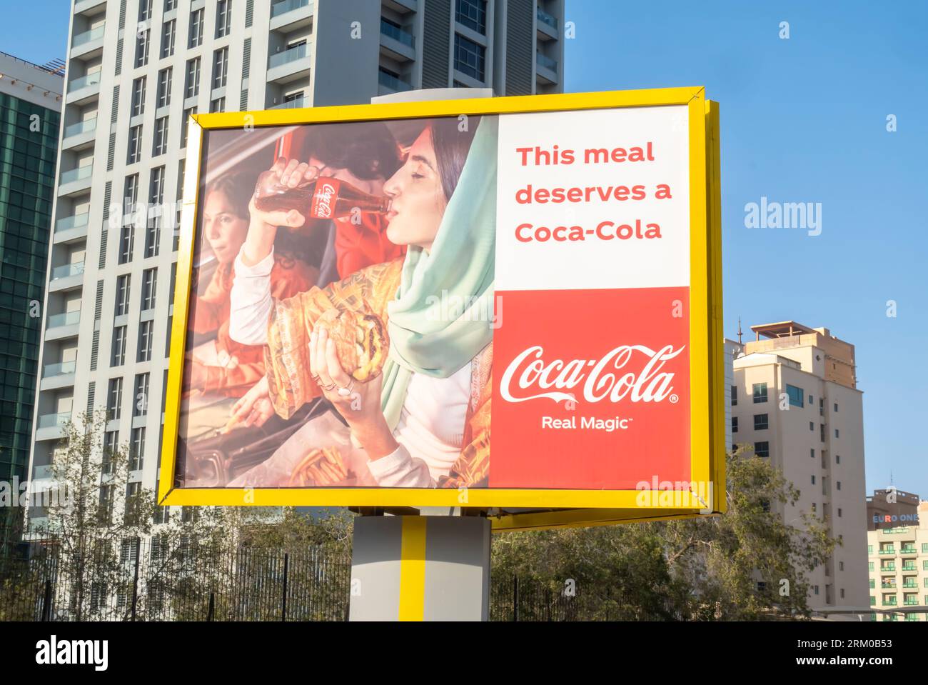 Coca-Cola Real Magic Außenwand-Werbekampagne Werbung auf der Straße in Manama Bahrain. Arabische Frau, die Coca-Cola-Werbung trinkt Stockfoto