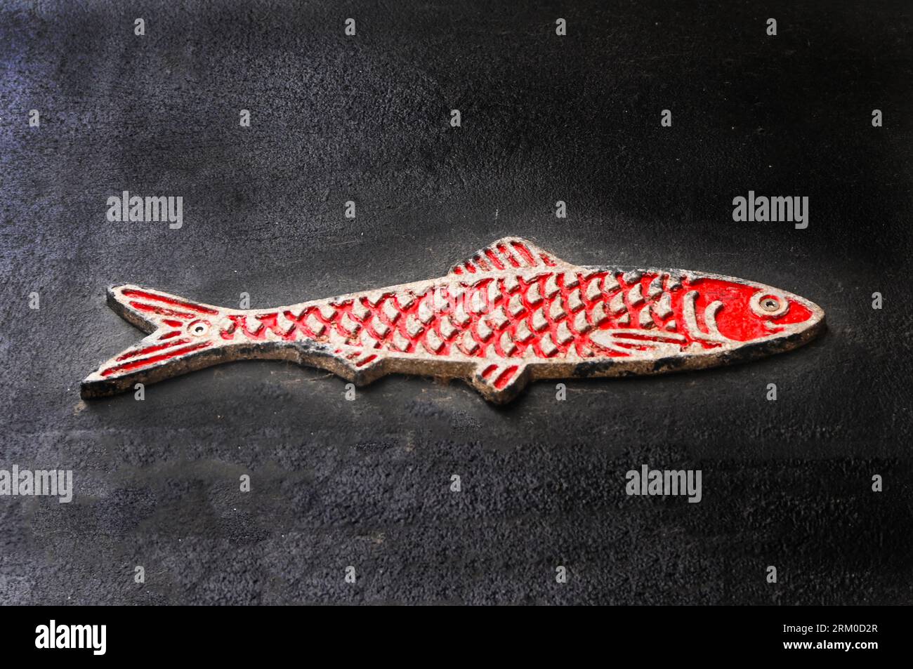 Fischdekoration aus Beton an der Wand verschraubt Stockfoto