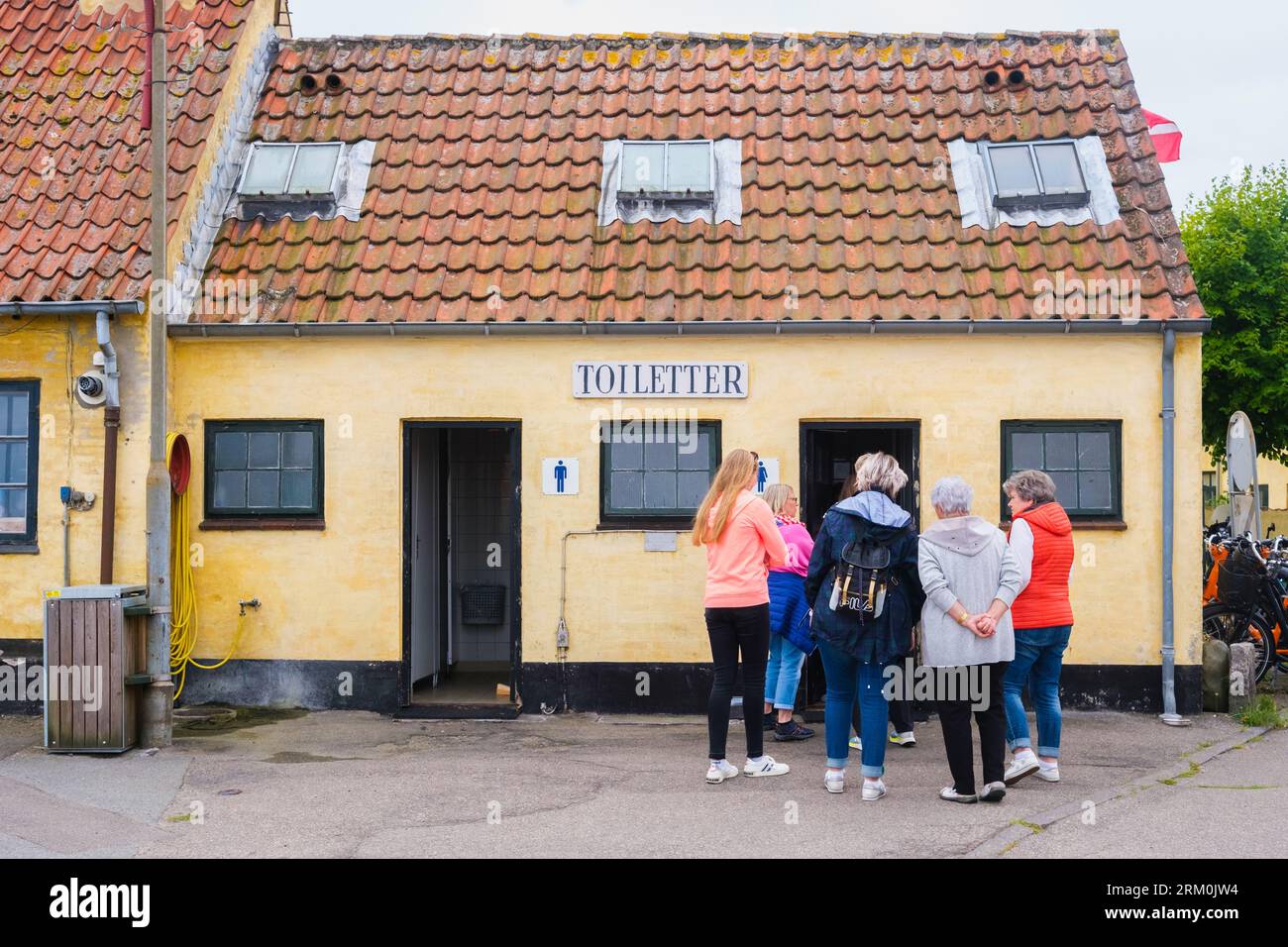 kopenhagen, dänemark - 8. august 2023: Gruppe von Frauen Schlange an der Tür einer Toilette, während die Männer leer sind. Stockfoto