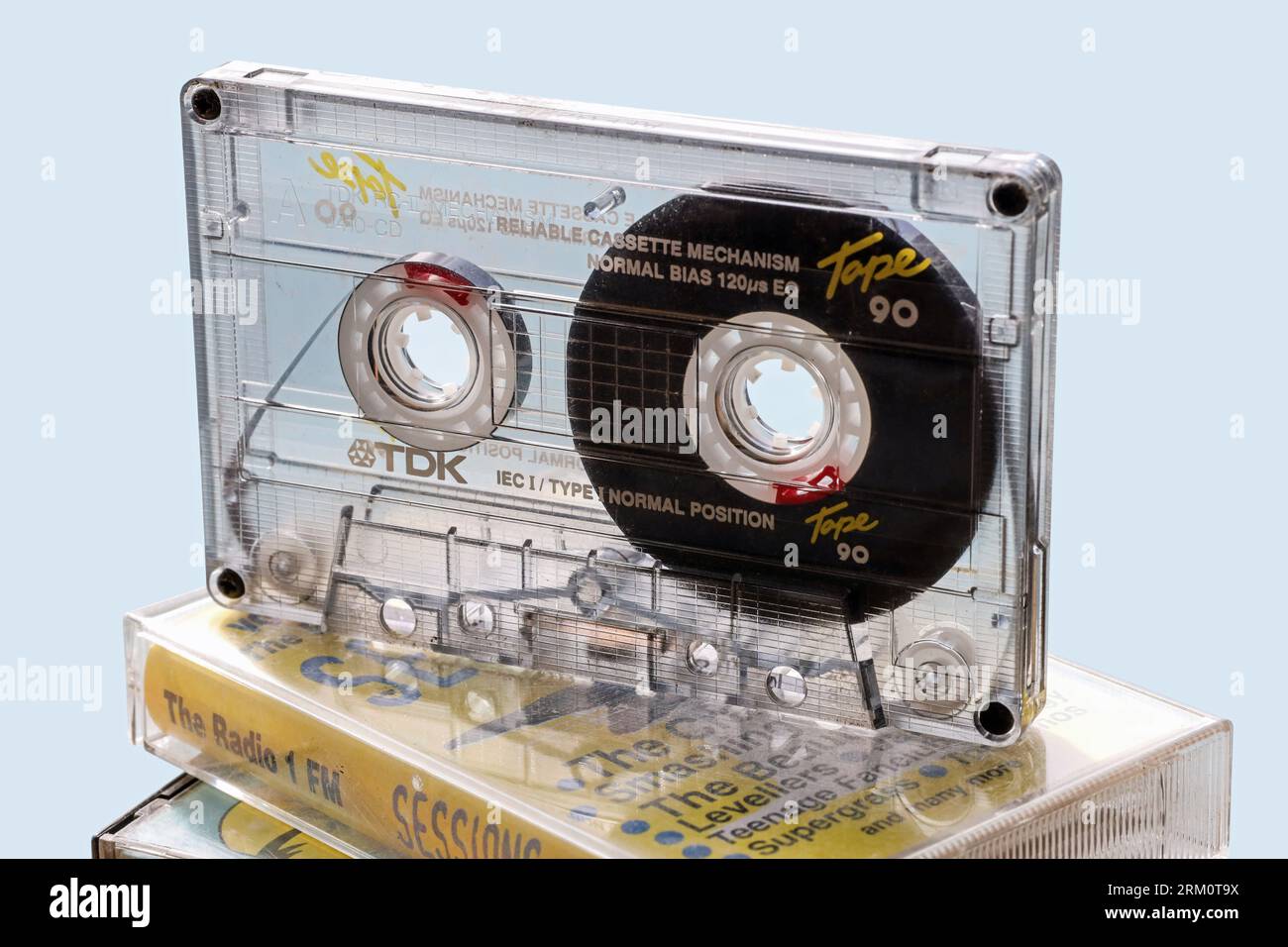 Das durchsichtige Gehäuse einer TDK-Kompaktkassette zeigt das komplizierte interne Layout. Kompakte Audio-Kassettenbänder, die für Heimaufnahmen beliebt sind, mit dem C90 in Stockfoto