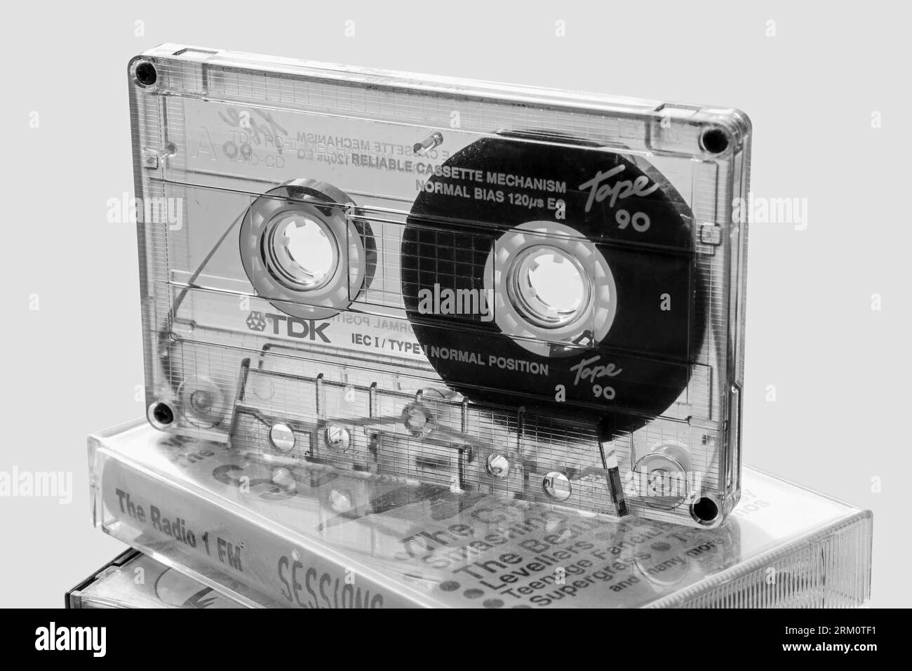 Das monochrome Bild des durchsichtigen Gehäuses einer TDK-Kompaktkassette zeigt das komplizierte interne Layout. Kompakte Audio-Kassettenbänder, beliebt für die Heimkino-Wiedergabe Stockfoto
