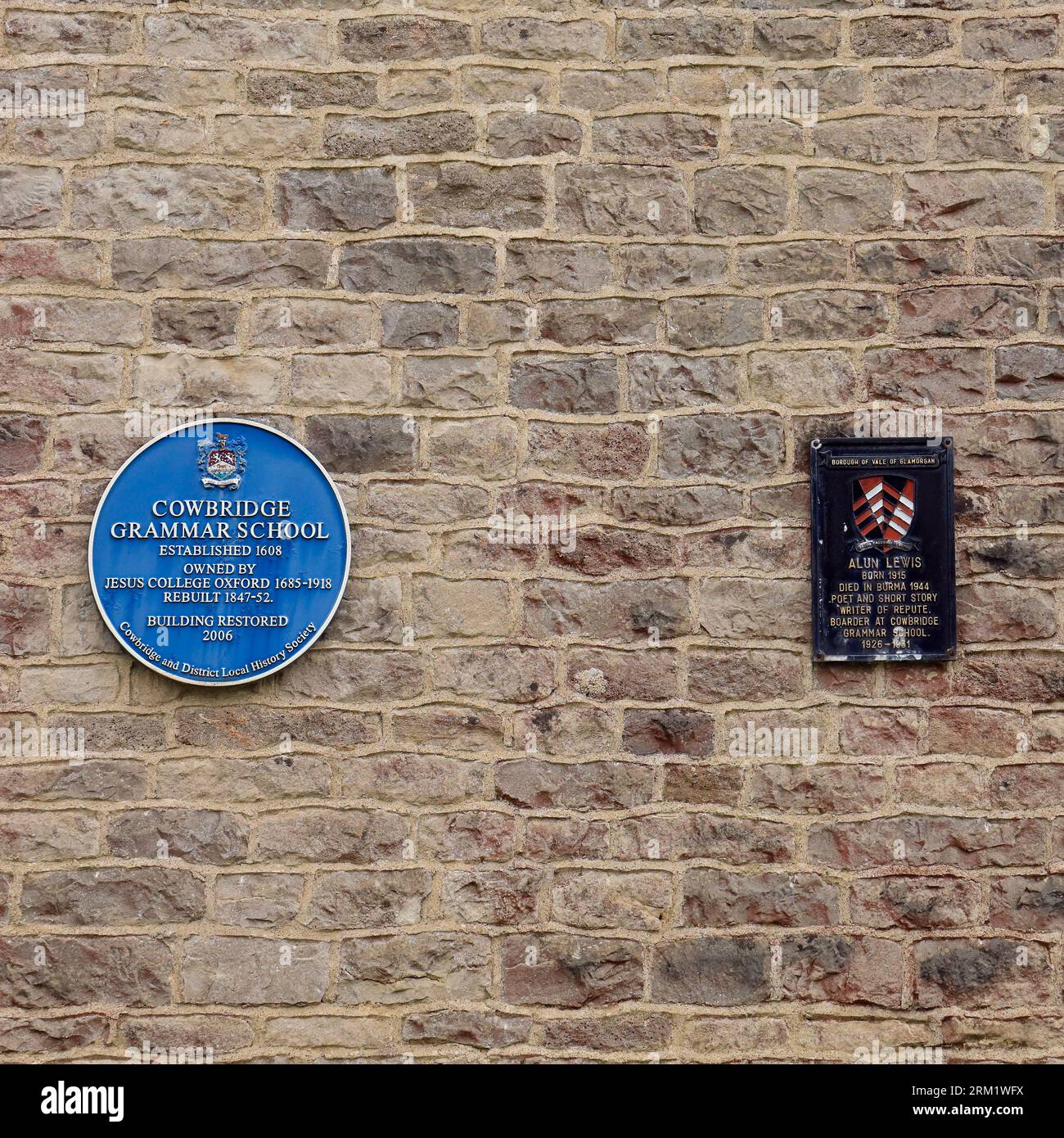 Blaue Gedenktafel, Cowbridge Grammar School und Schild (für Alun Lewis) an einer Steinmauer. August 2023.cym Stockfoto