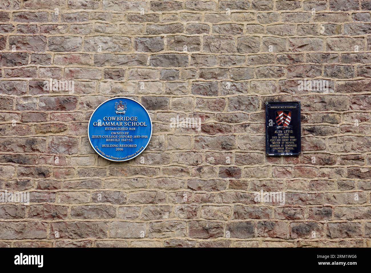 Blaue Gedenktafel, Cowbridge Grammar School und Schild (für Alun Lewis) an einer Steinmauer. August 2023.cym Stockfoto