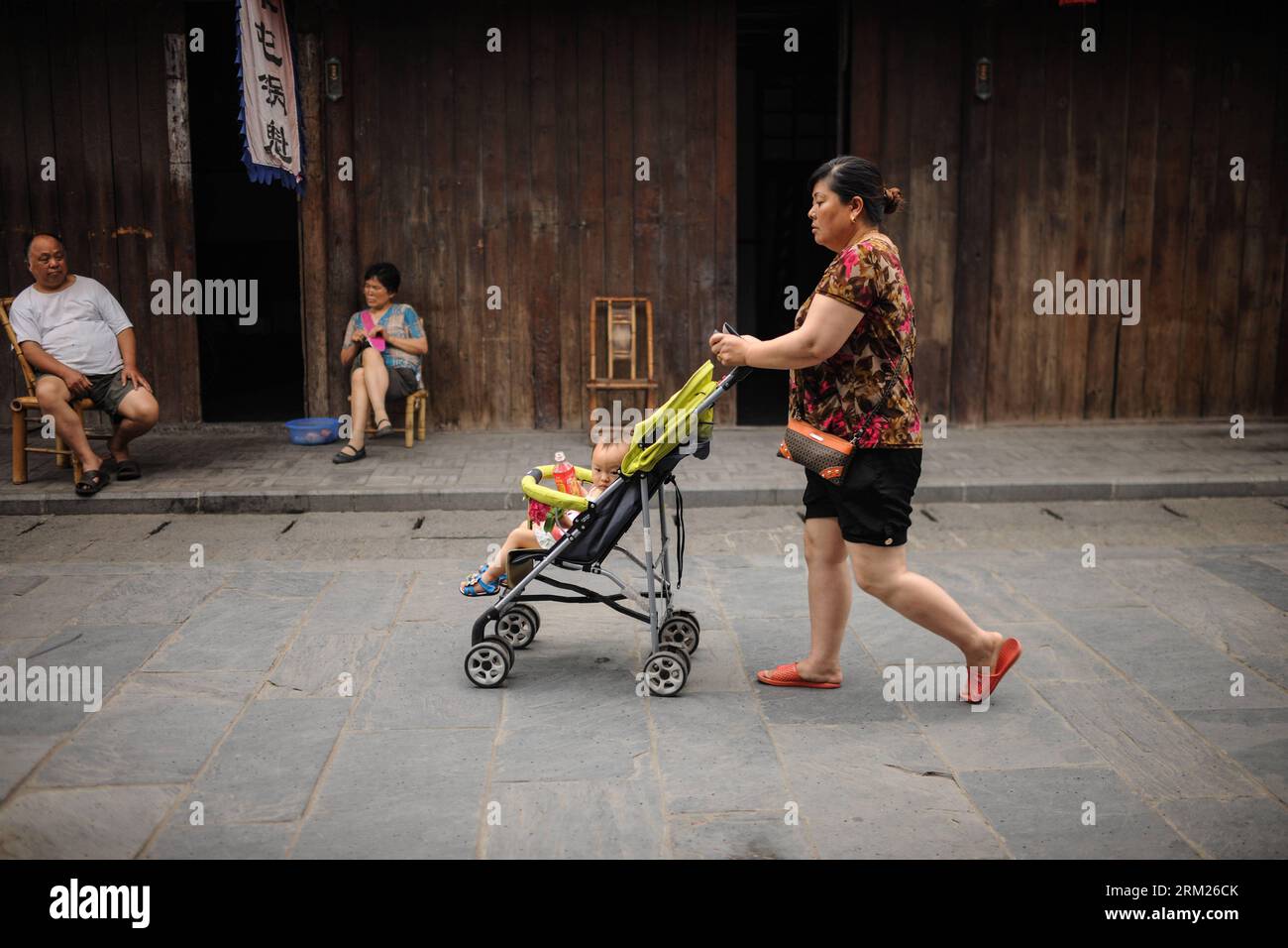 Bildnummer: 59709787 Datum: 23.05.2013 Copyright: imago/Xinhua CHENGDU, 23. Mai 2013 - A Woman with A Baby Walks on a Street in Anren, einer antiken Stadt im Dayi County von Chengdu, Hauptstadt der südwestchinesischen Provinz Sichuan, 23. Mai 2013. Anren Town wurde erstmals in der alten chinesischen Tang-Dynastie (618–907) erbaut. Die meisten Gebäude wurden in der späten Qing-Dynastie (1644–1911) und in der frühen Republik China (1911–1949) errichtet. Chengdu wird vom 6. Bis 8. Juni das Global Fortune Forum ausrichten, eine Veranstaltung, die vom amerikanischen Magazin Fortune organisiert wird. (Xinhua/Shen Hong) (wqq) CHINA-CHENGDU-und-ANTIKE STADT-L Stockfoto