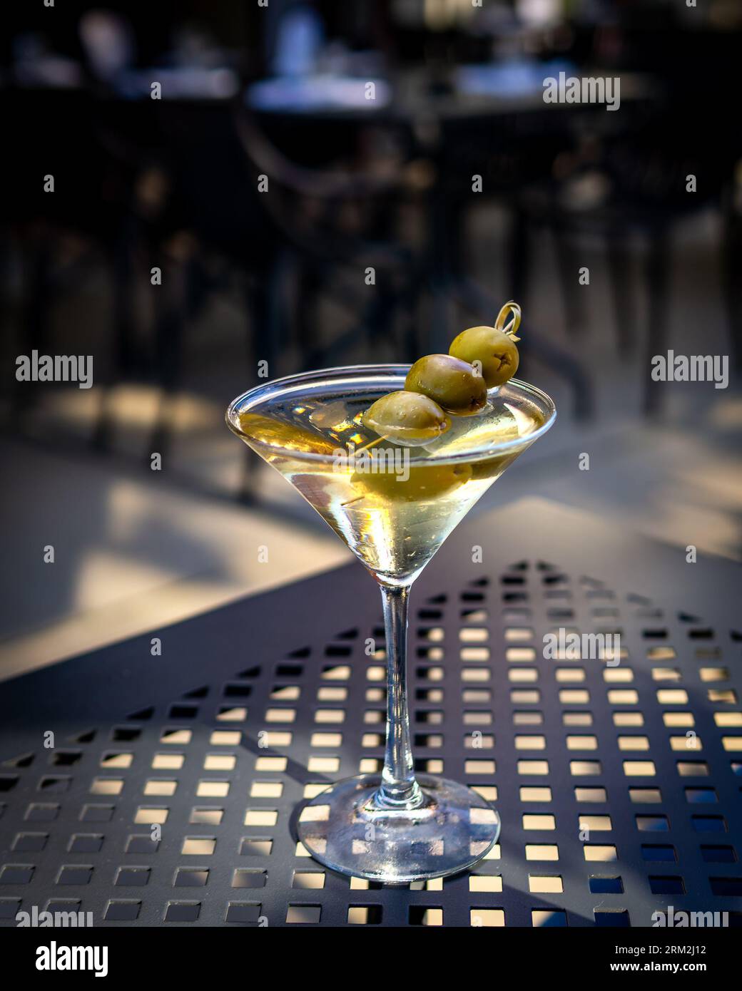 Piermont, NY - USA - 20. August 2023 vertikales Bild eines schmutzigen Martini, garniert mit drei Oliven, direkt nach oben serviert, mit einer geringen Feldtiefe. Stockfoto